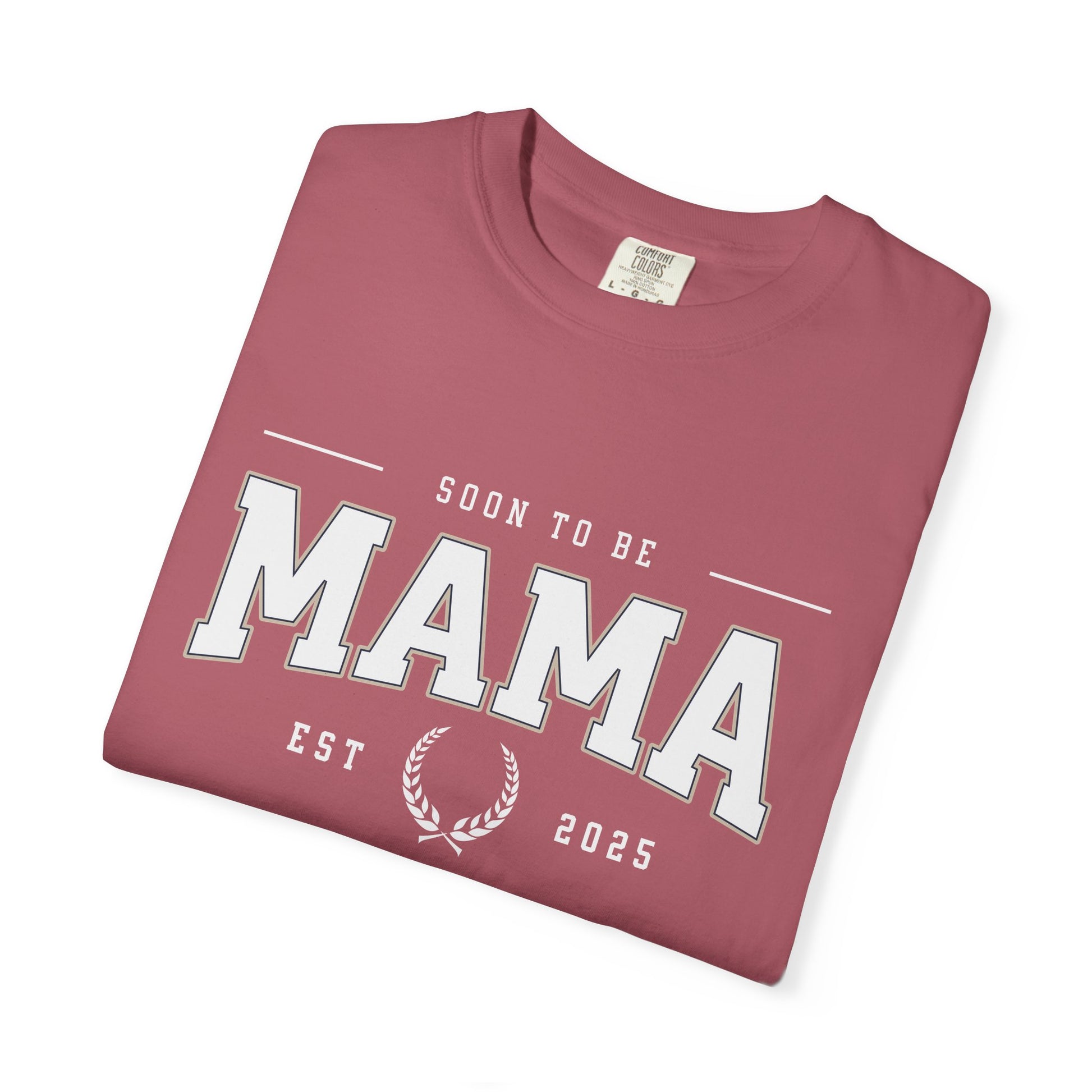 Folded maroon t-shirt with 'Soon to be Mama Est 2025' text on a white background
