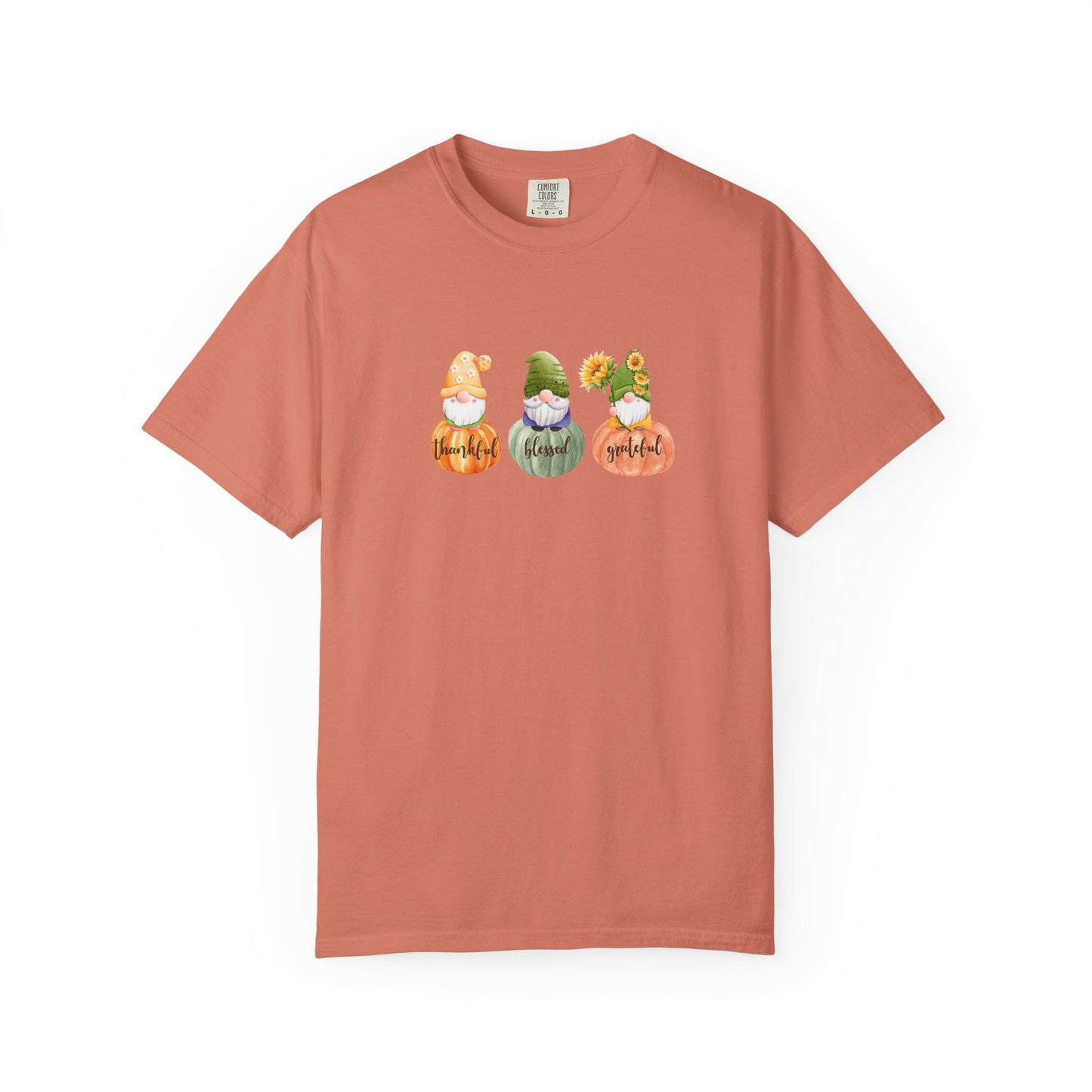 Coral t-shirt with three cartoon gnomes and text on a white background