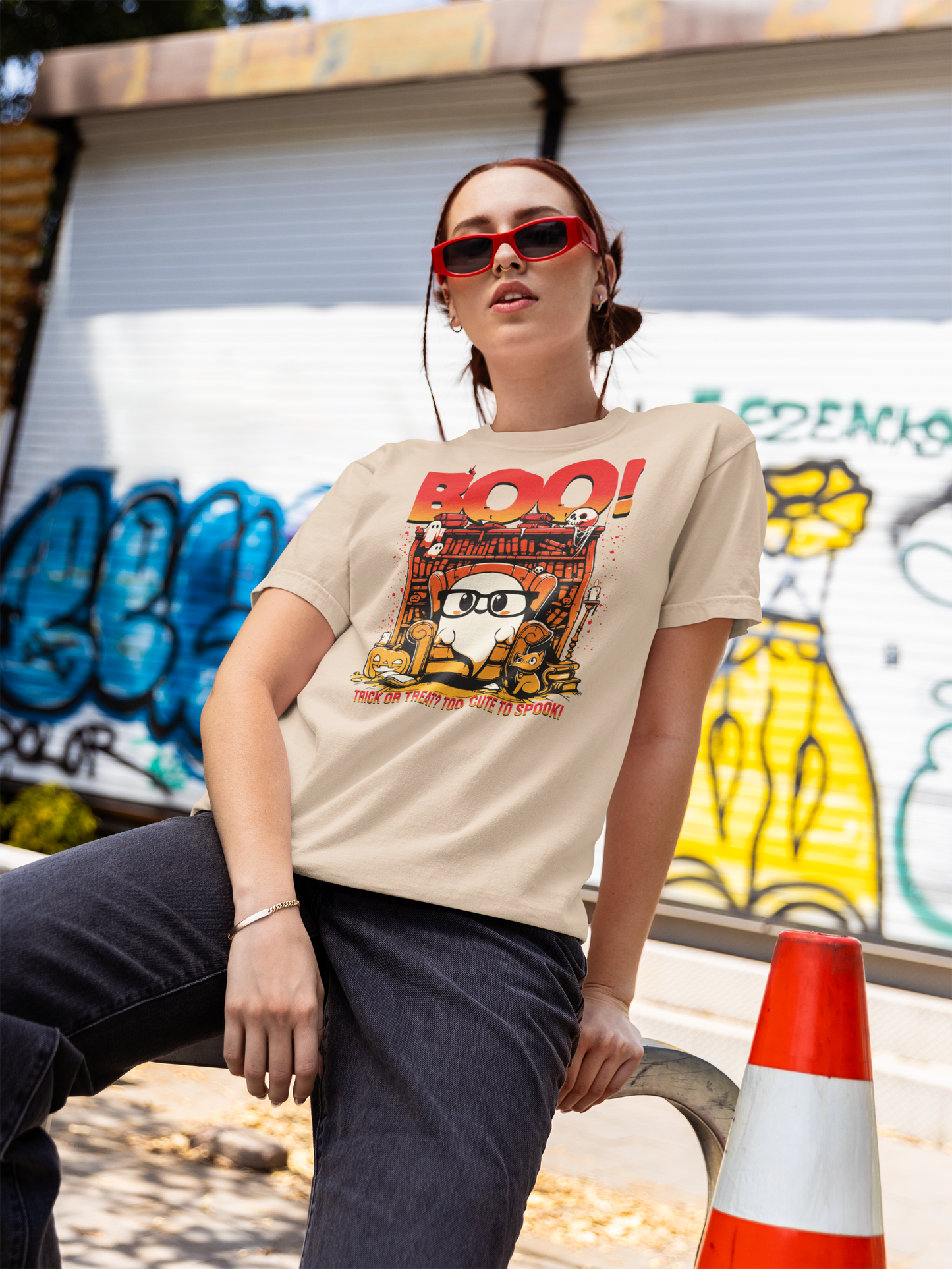 Person wearing a graphic t-shirt with a design in front of a graffiti-covered wall.