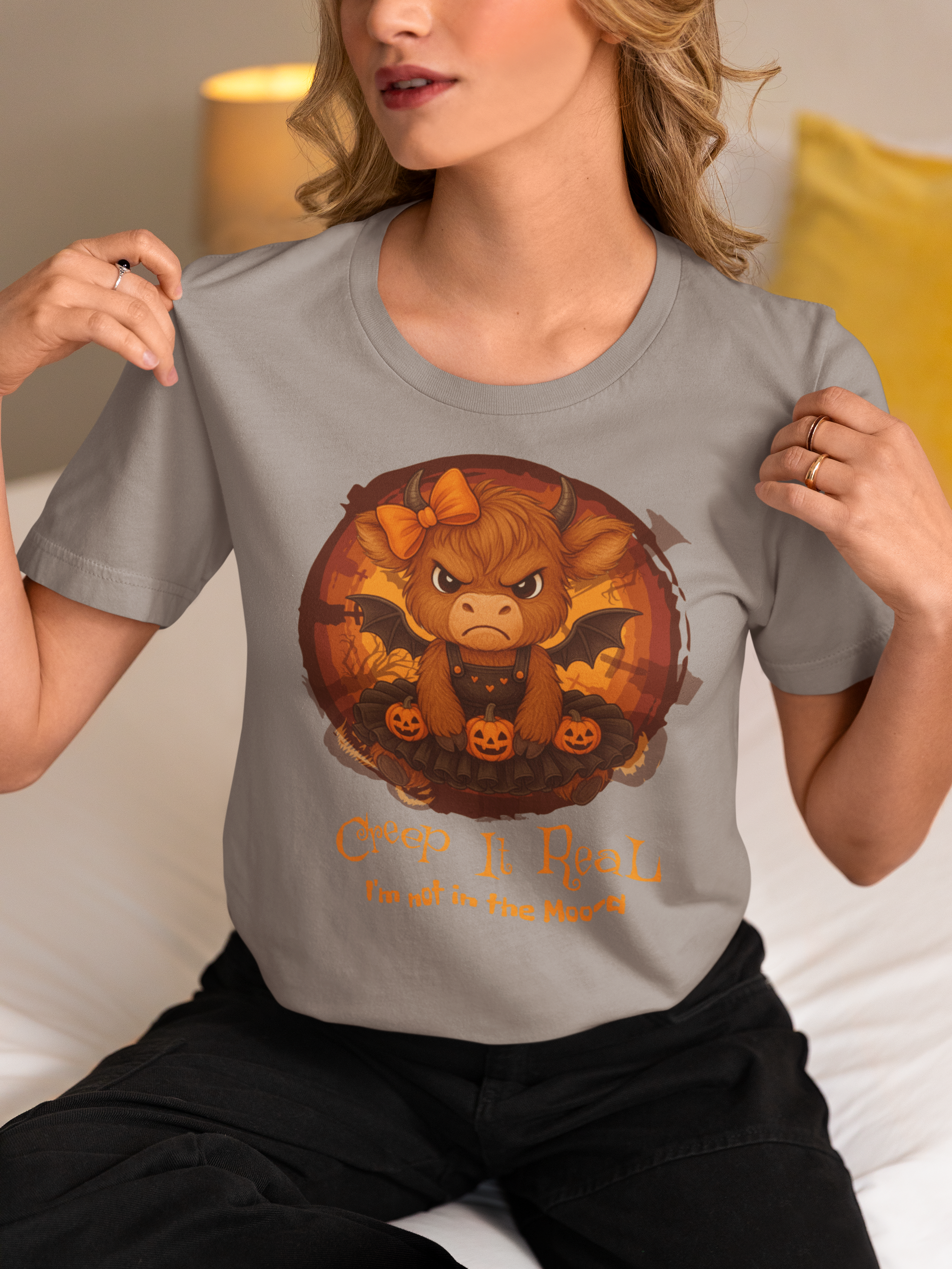 Person wearing a gray t-shirt with a graphic design of a bull with horns and pumpkins, and text.