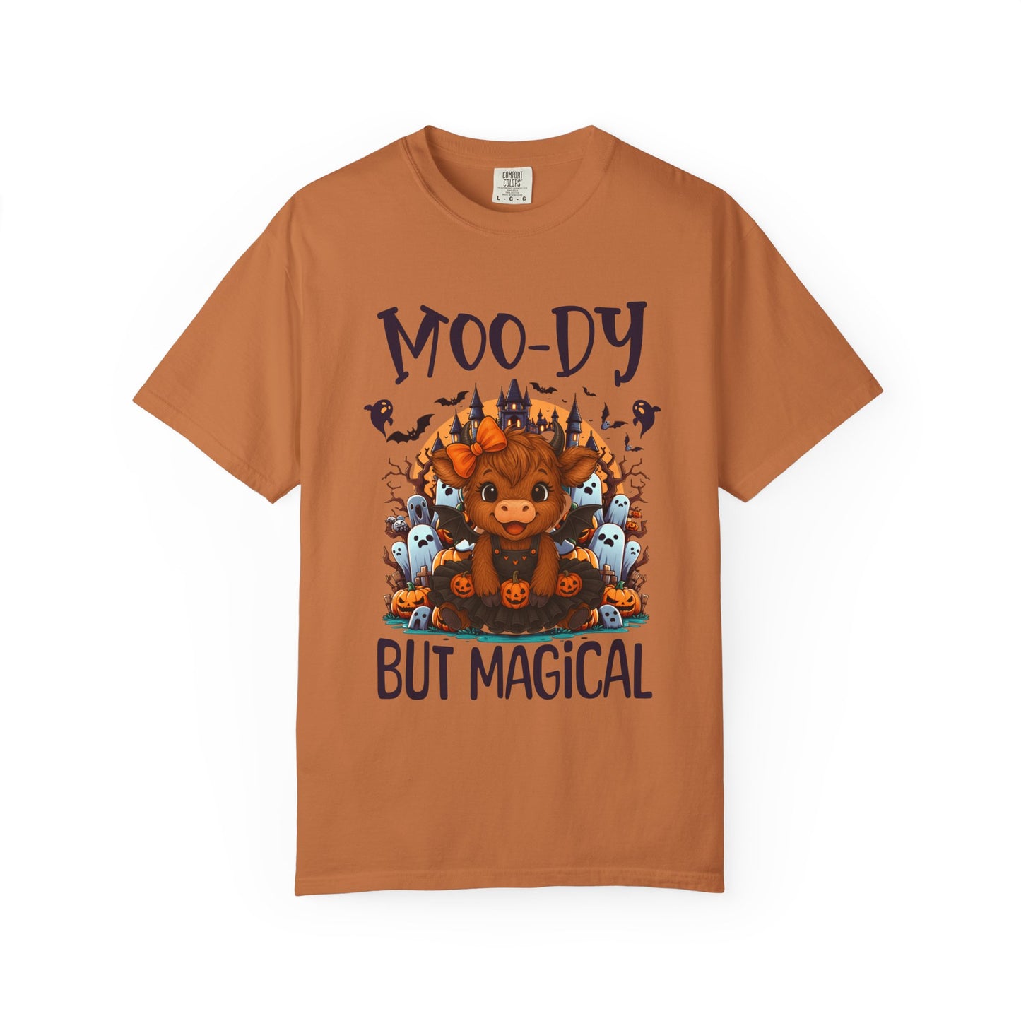 Brown t-shirt with a graphic of a cow and text 'Moo-dy But Magical' on a white background