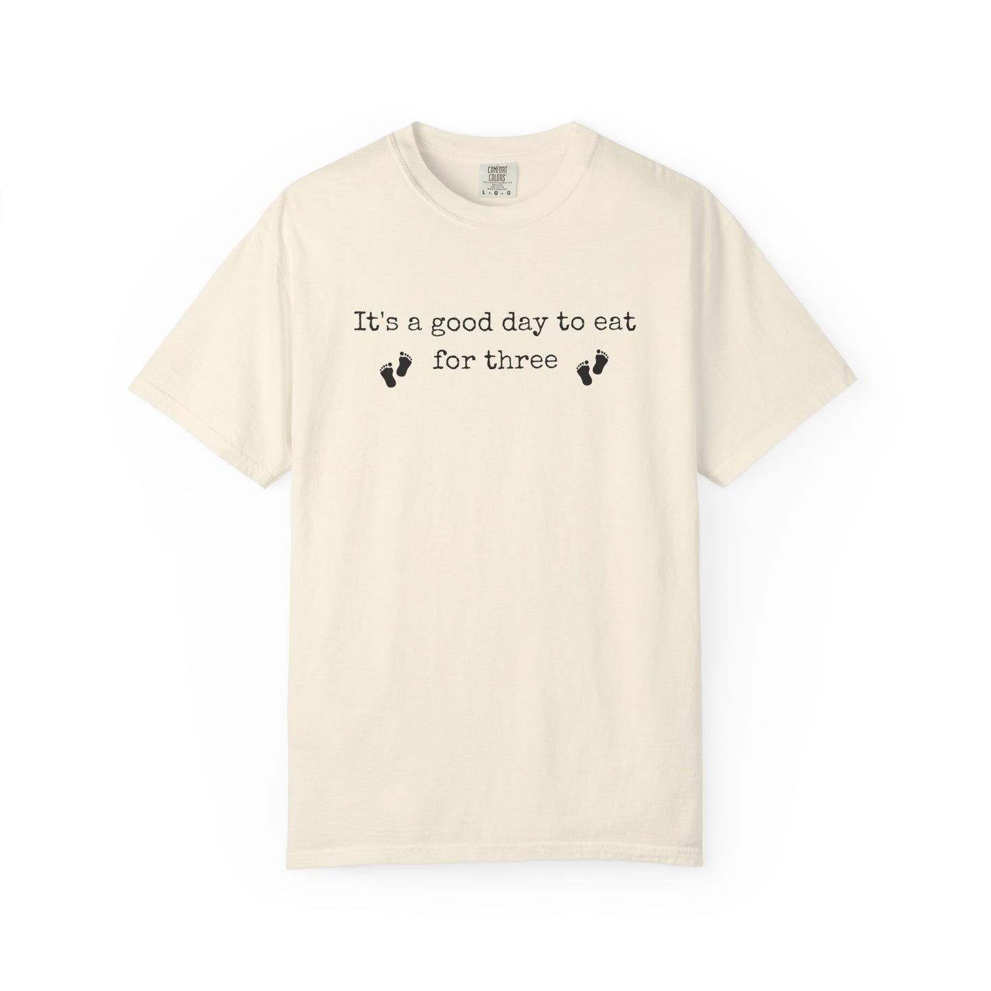 Beige t-shirt with text 'It's a good day to eat for three' on a white background
