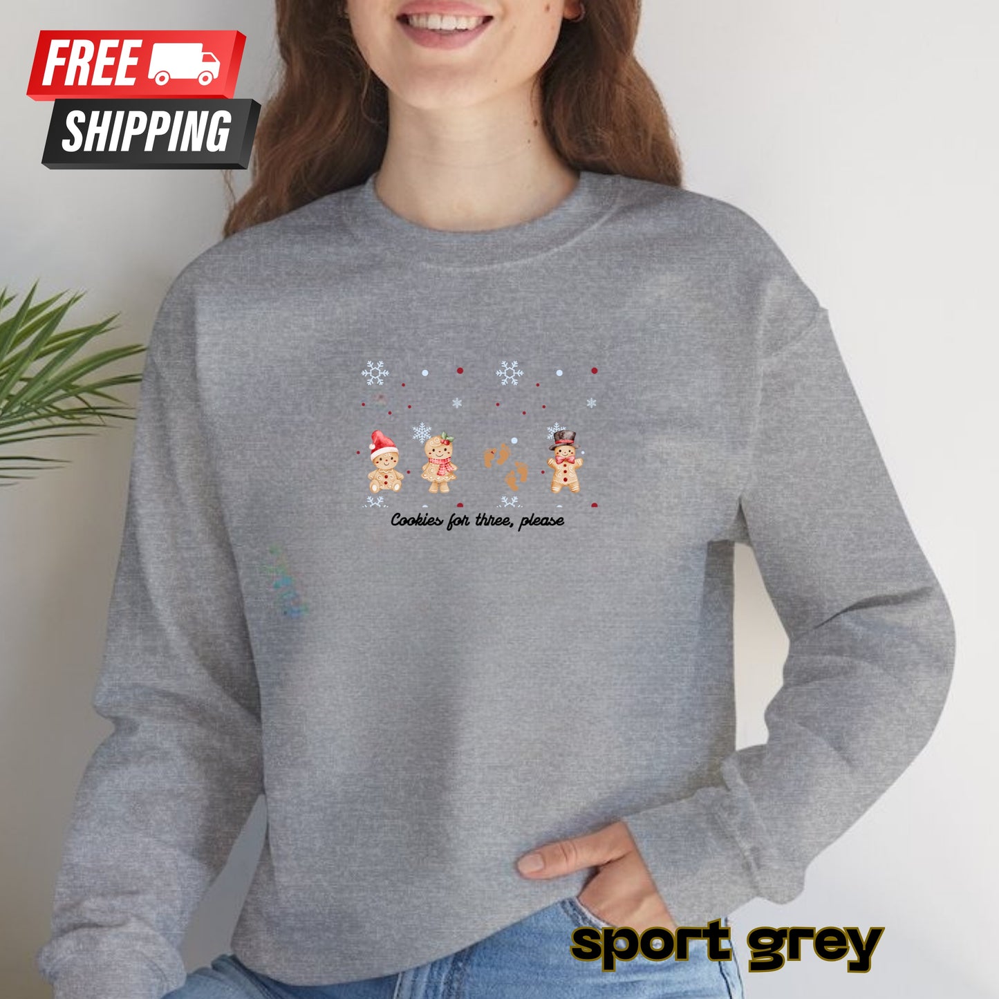 Person wearing a gray sweatshirt with Christmas-themed design and 'free shipping' label.