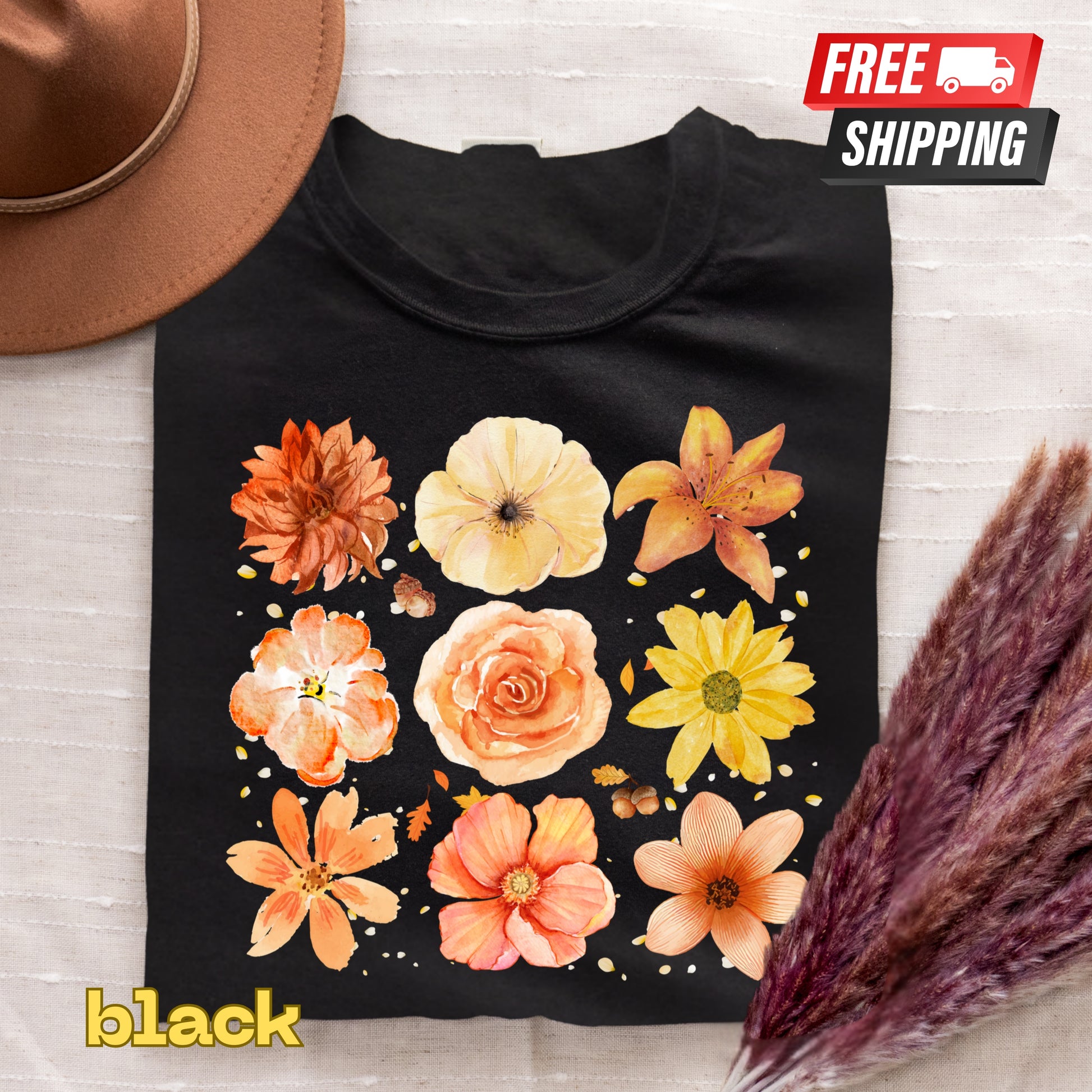 Black t-shirt with colorful floral design on a light wooden surface with free shipping label.