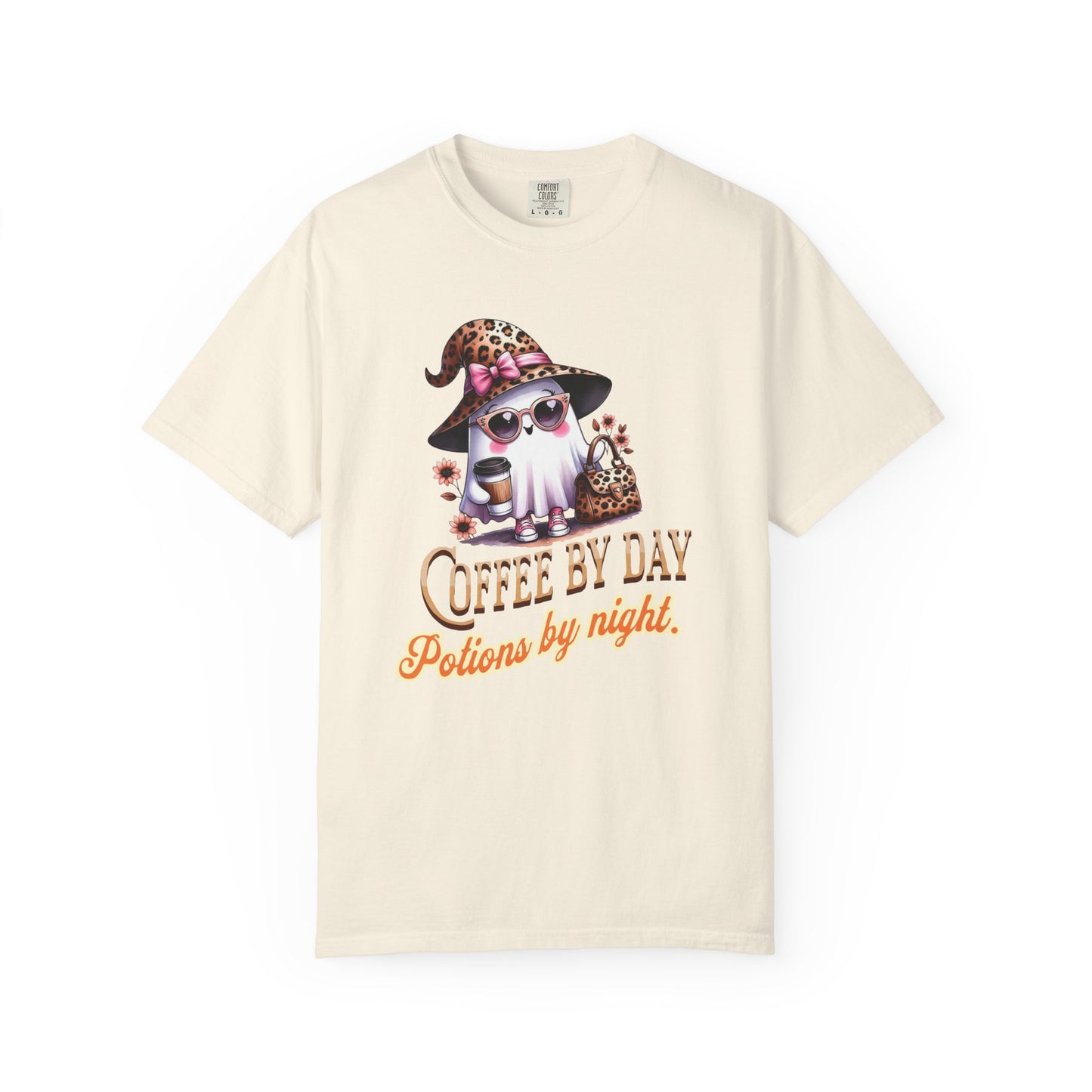 Beige t-shirt with a graphic of a cat in a witch hat and sunglasses, text 'Coffee by Day, Potions by Night' on a white background.