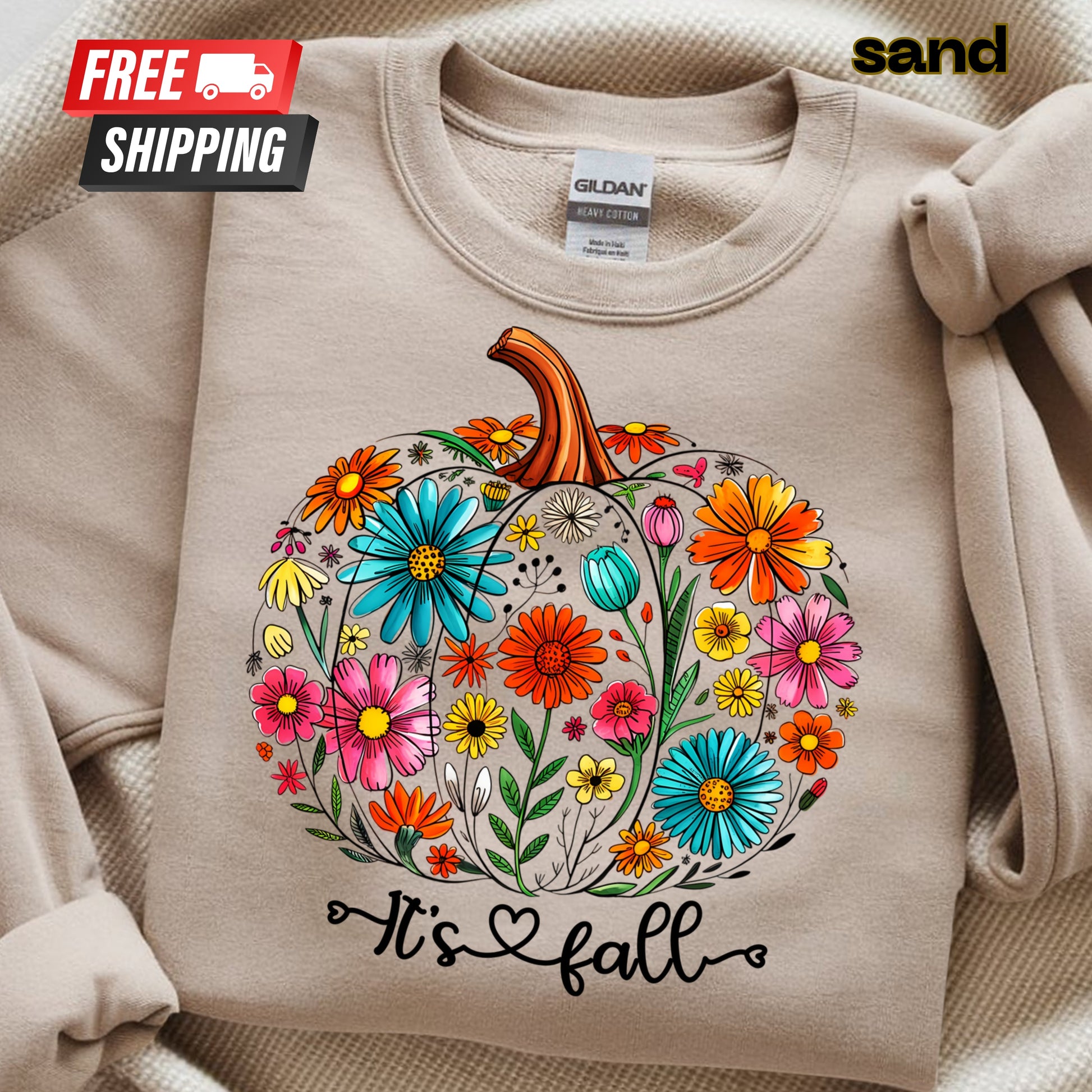 Beige sweatshirt with a floral pumpkin design and 'It's fall' text, featuring a Gildan label.