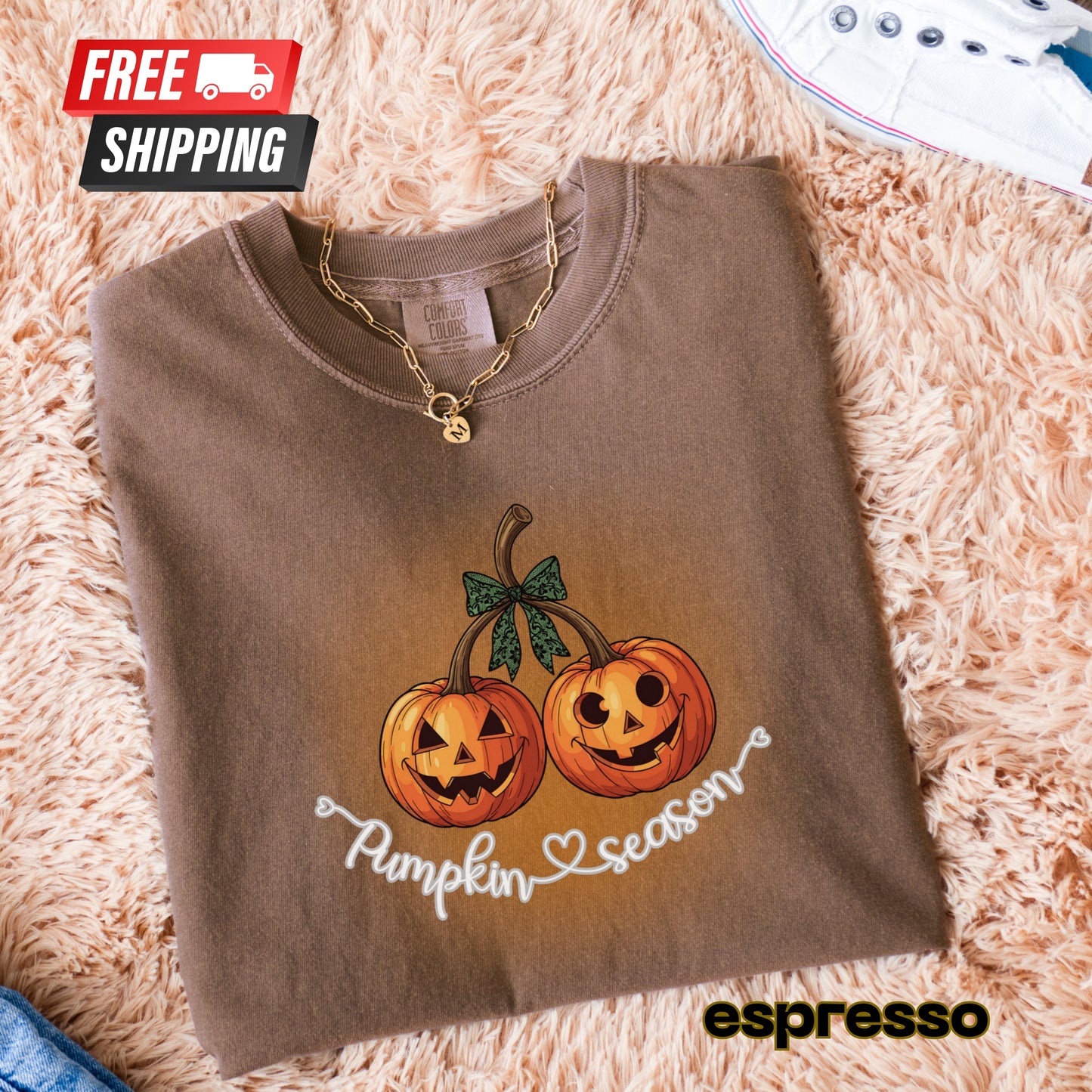 Folded brown sweatshirt with pumpkin design and 'Pumpkin Season' text on a fluffy surface, featuring free shipping icon.