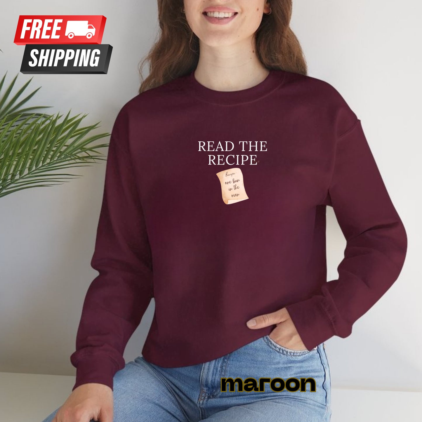 Person wearing a maroon sweatshirt with 'Read the Recipe' text and a recipe card graphic, sitting against a white wall.