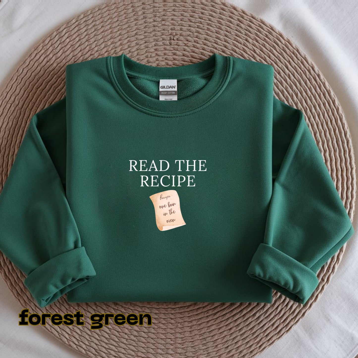 Green sweatshirt with 'Read the Recipe' text on a woven mat