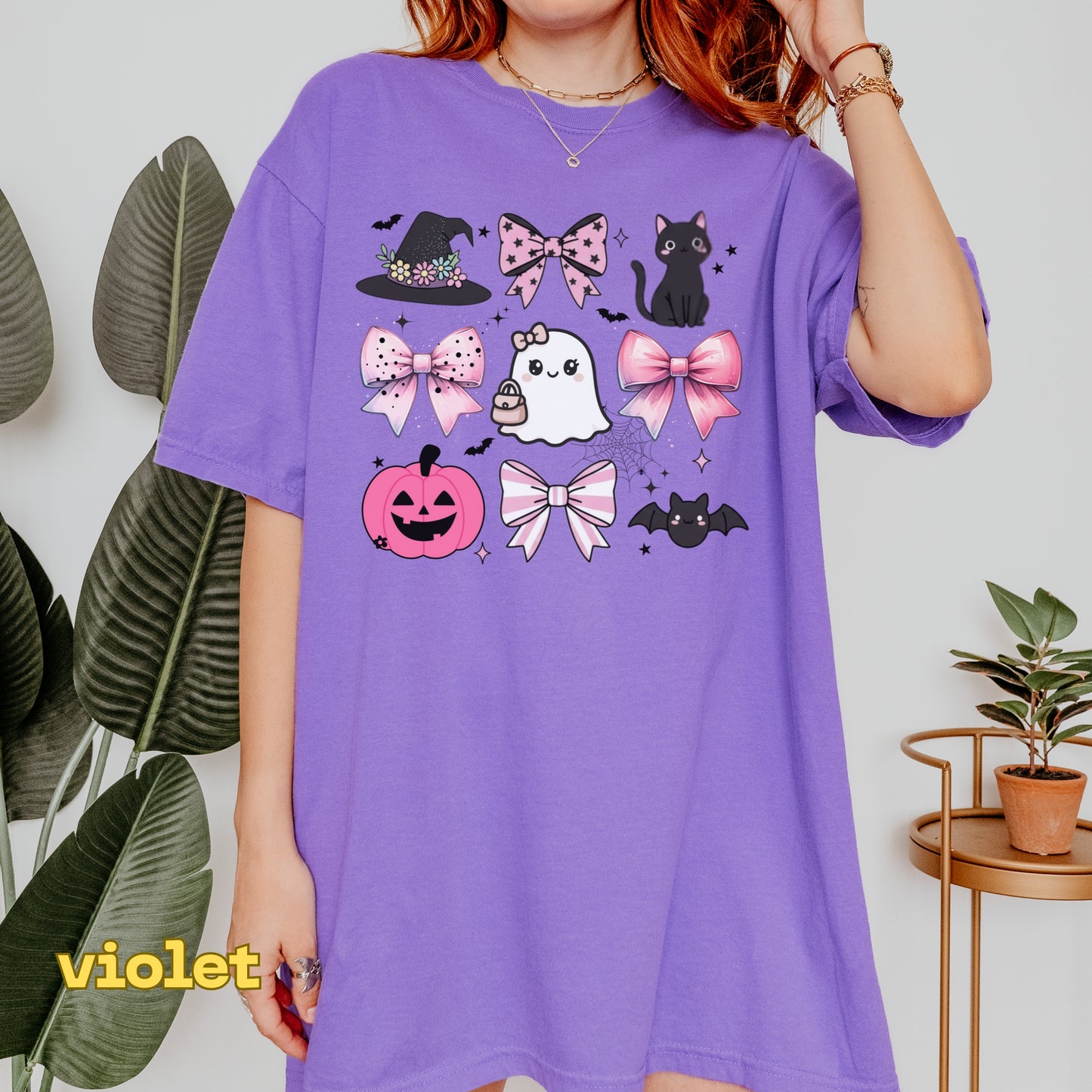 Person wearing a purple t-shirt with Halloween-themed graphics against a white background.