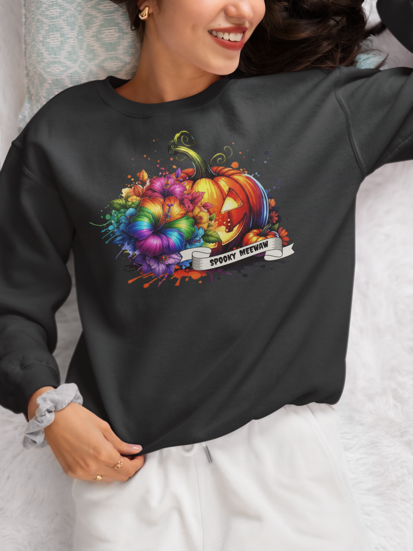 Person wearing a black sweatshirt with a colorful Halloween design.