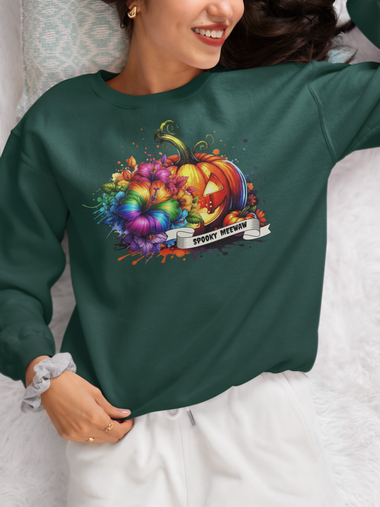 Person wearing a green sweatshirt with a colorful pumpkin design and text.
