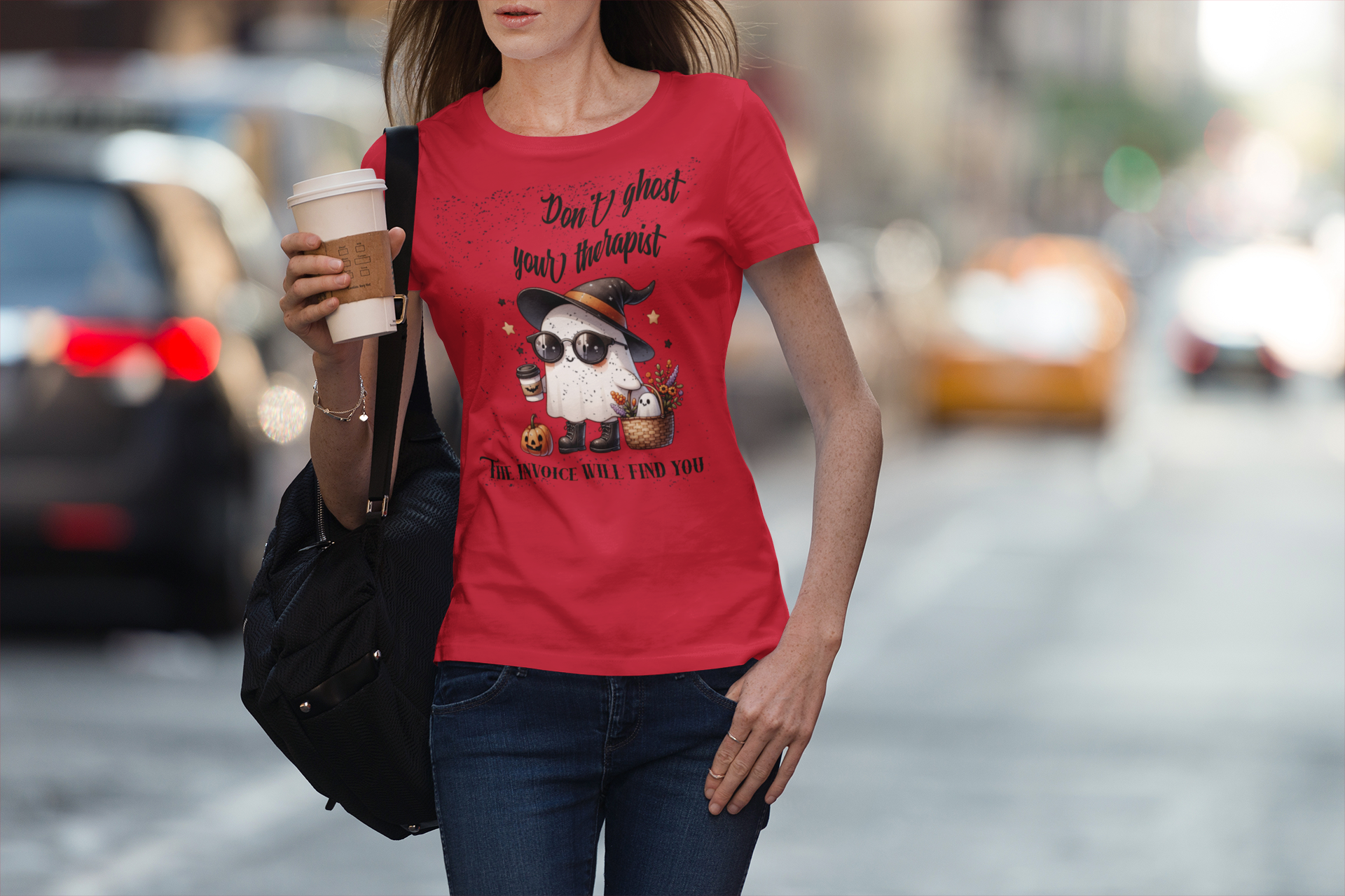 Woman wearing a red t-shirt with a graphic design on a city street.