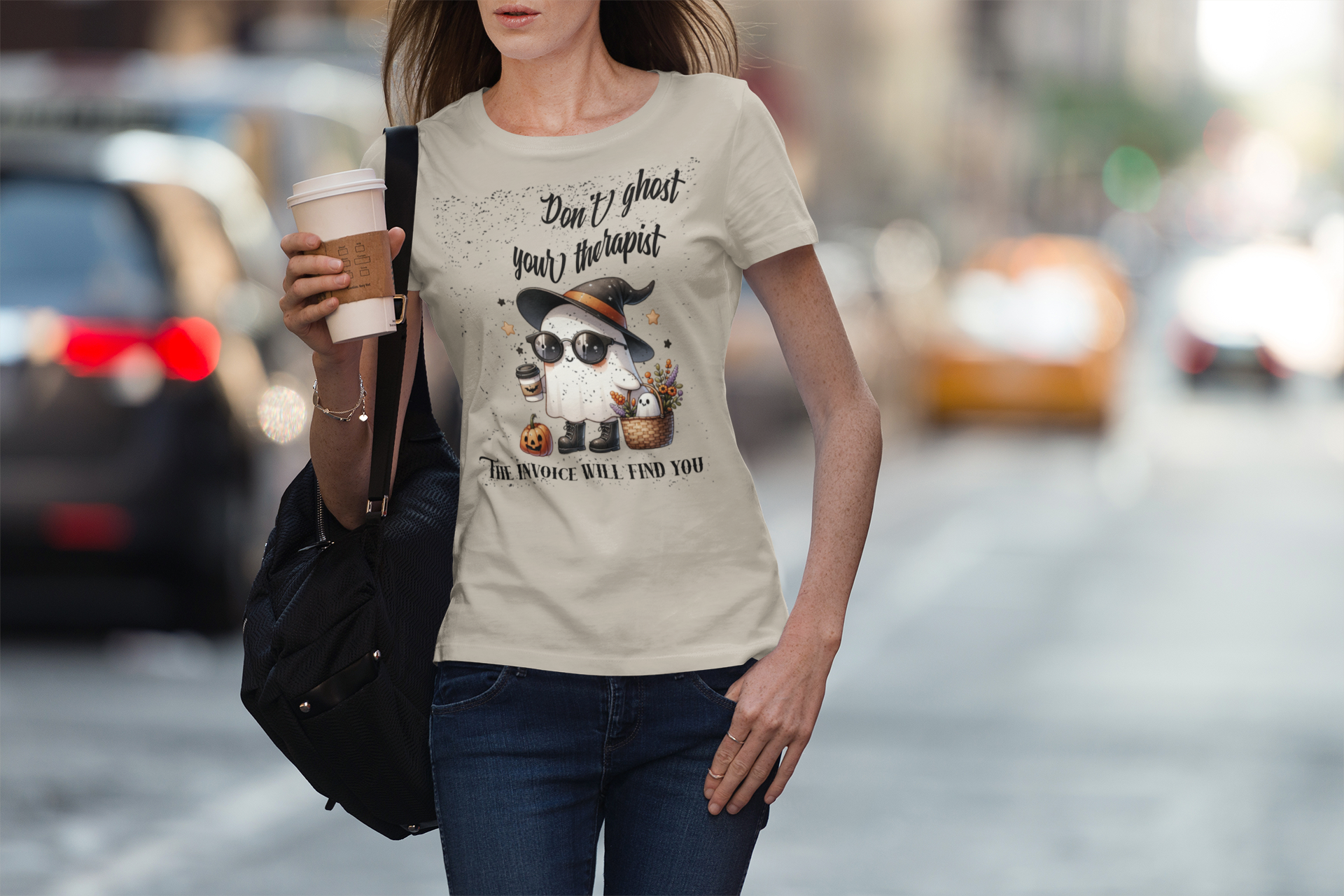 Woman walking on a street wearing a t-shirt with a graphic design and text.