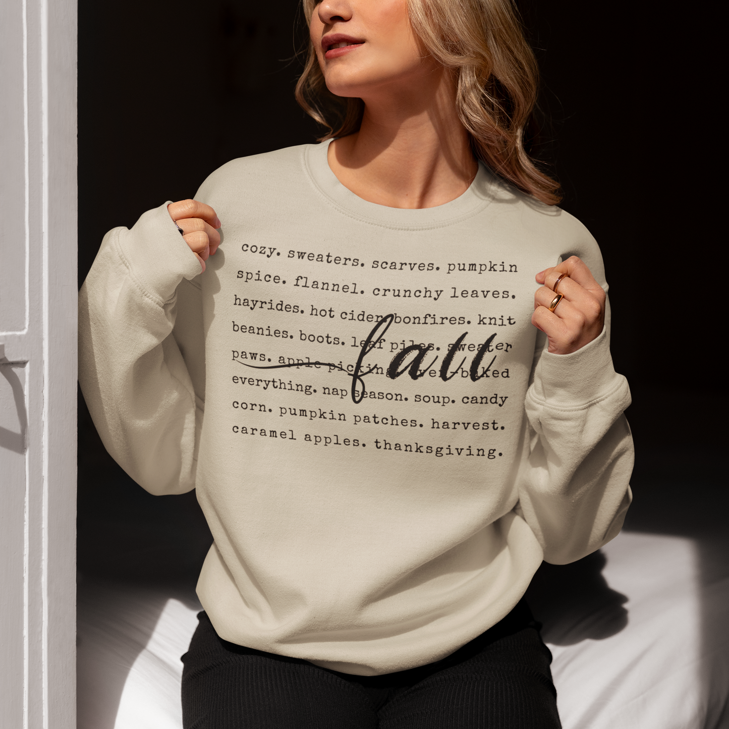 Person wearing a light gray sweatshirt with 'fall' text design.