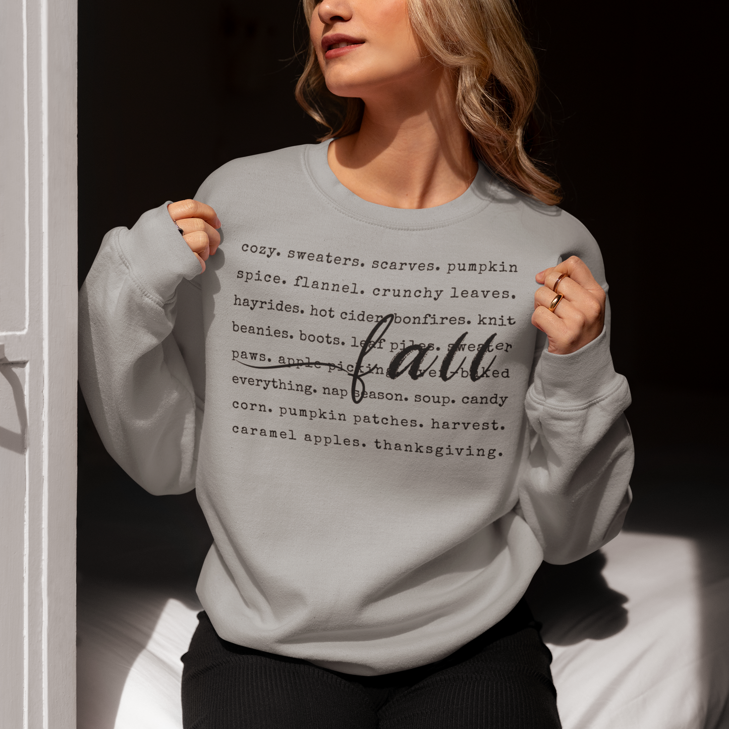 Person wearing a gray sweatshirt with 'fall' text design.