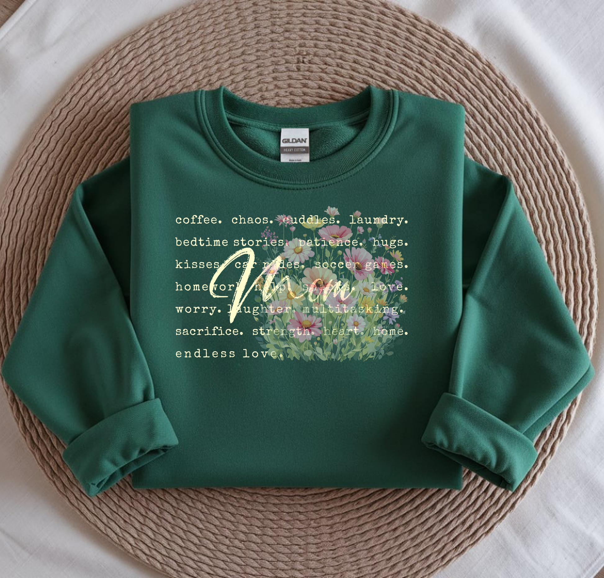 Green sweatshirt with floral design and text on a woven mat