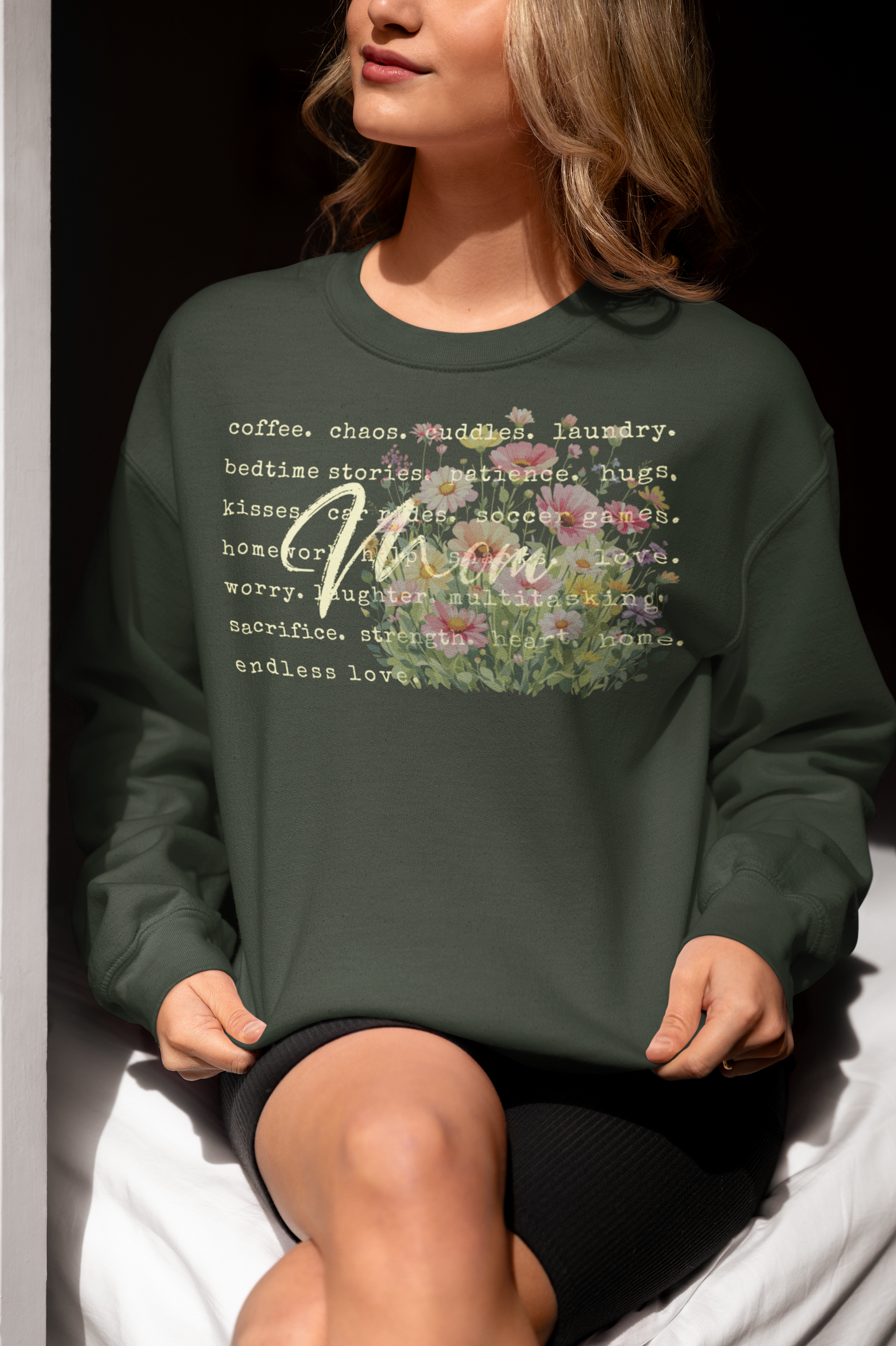 Person wearing a green sweatshirt with text and floral design