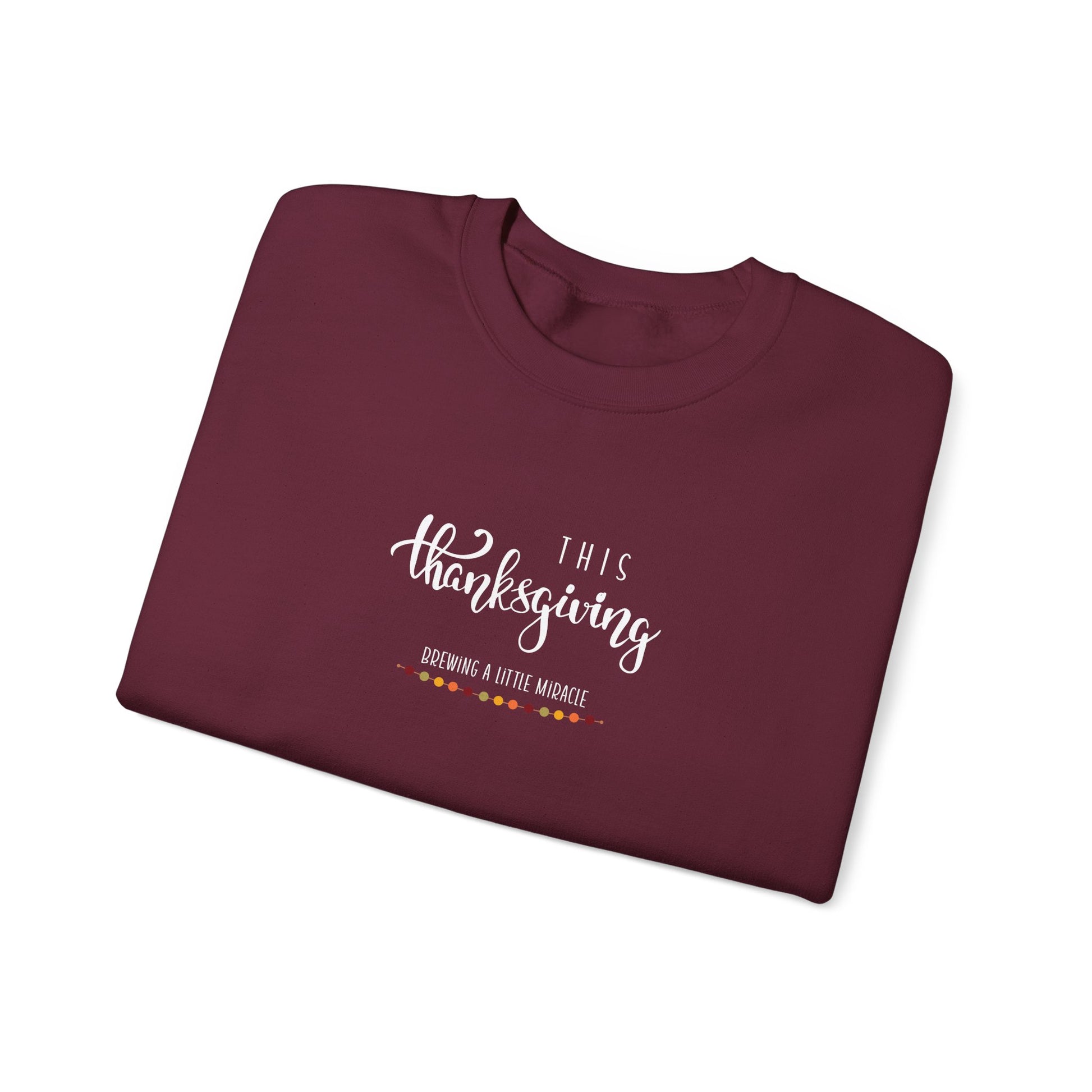 Folded maroon sweatshirt with 'This Thanksgiving' text on a white background