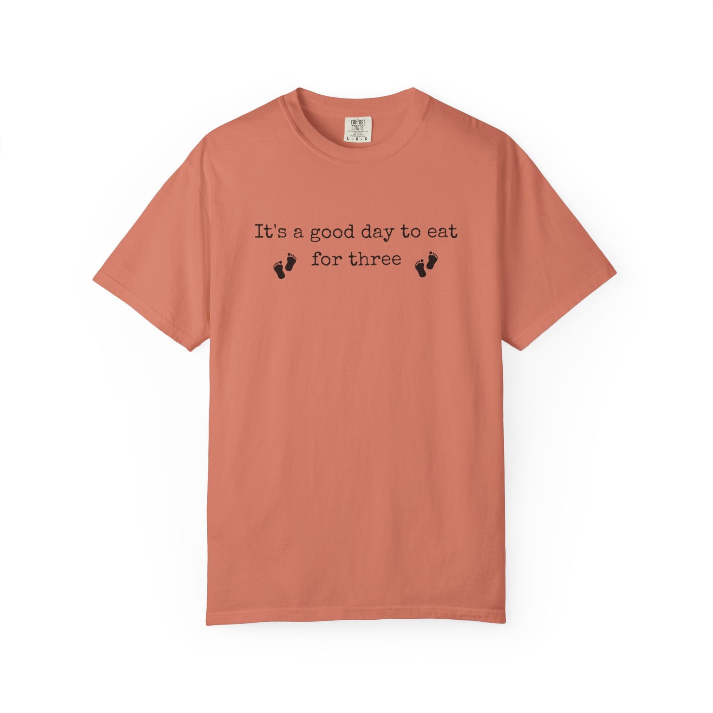 Coral t-shirt with text and footprints on a white background