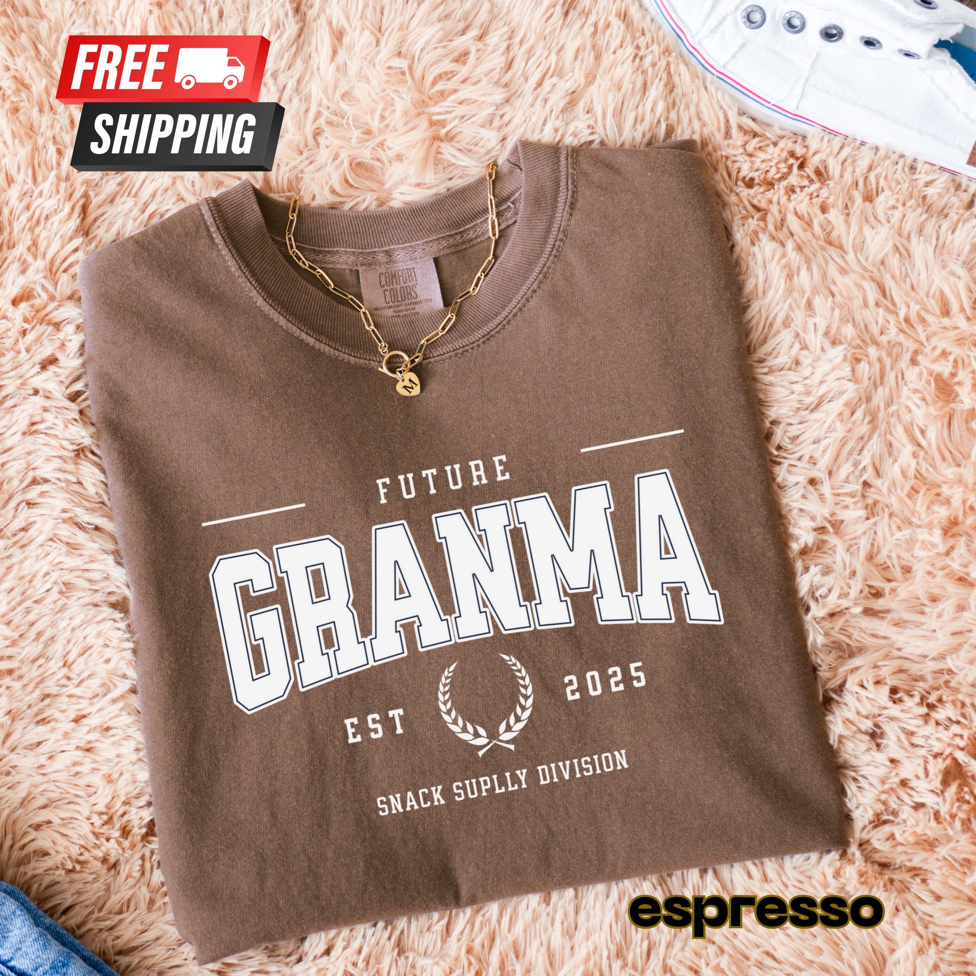 Folded brown sweatshirt with 'Future Granma' text on a fluffy beige surface, featuring free shipping icon and espresso brand name.