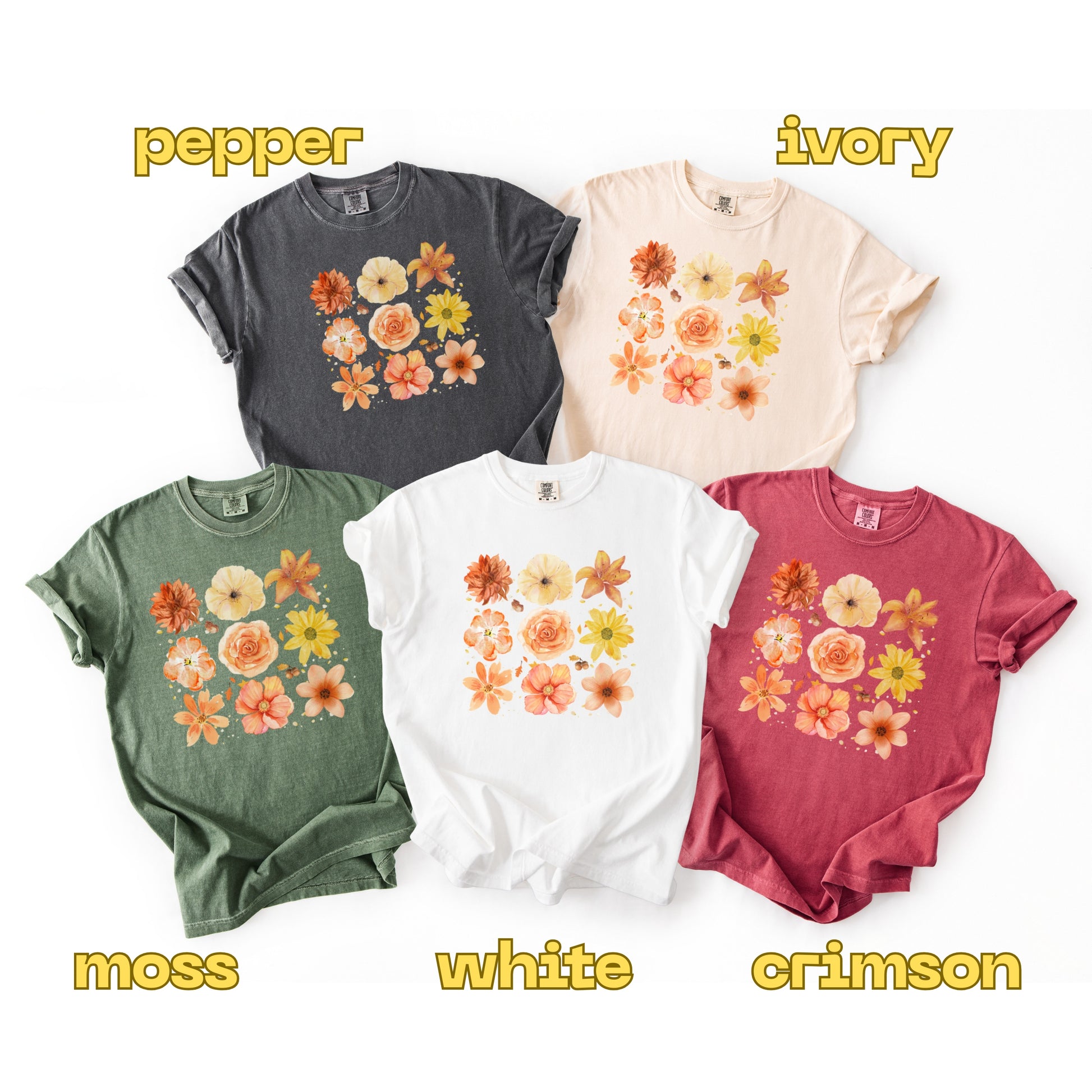 Five t-shirts in different colors with floral designs on a white background