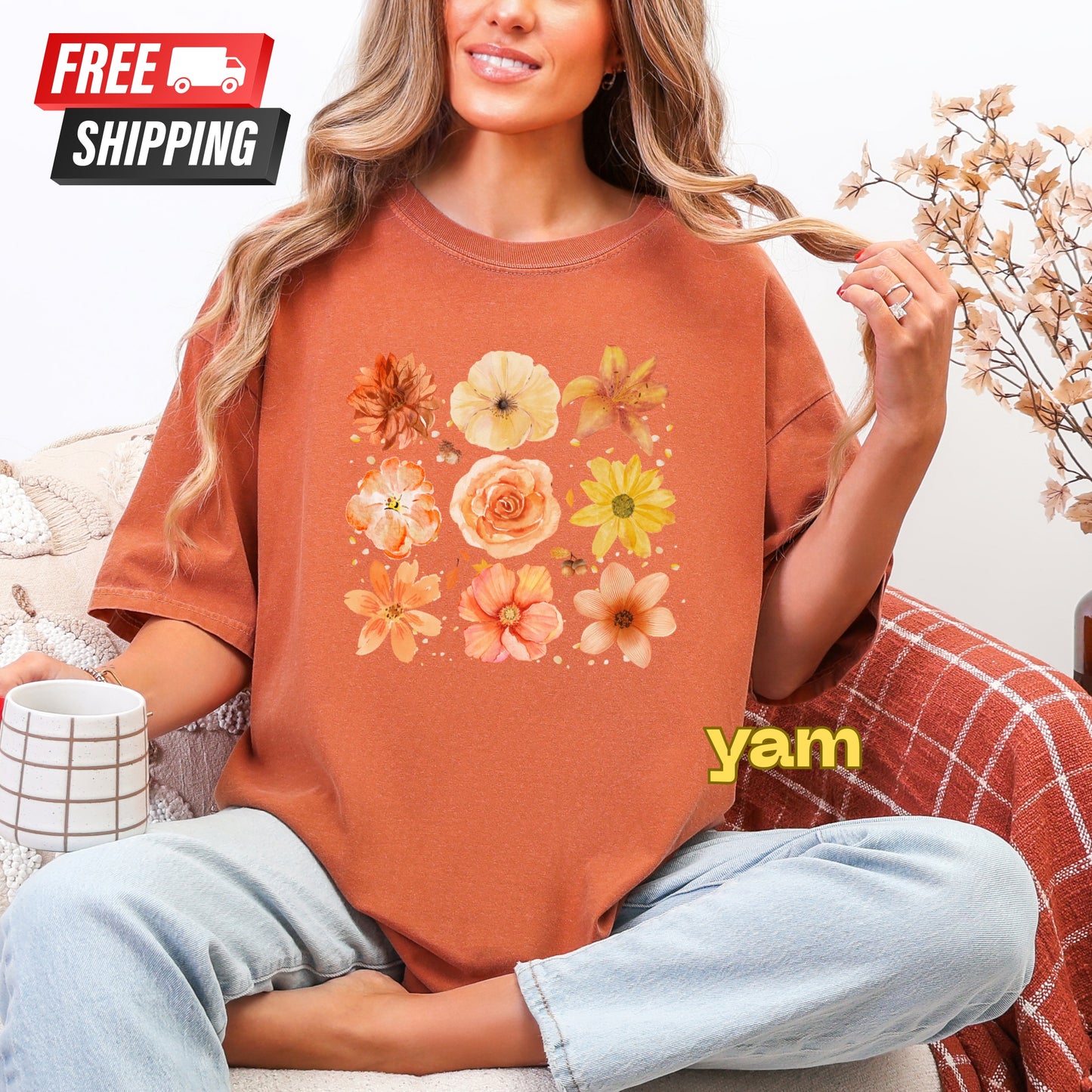 Person wearing a floral-patterned orange t-shirt with 'yam' branding, sitting on a couch with free shipping text above.