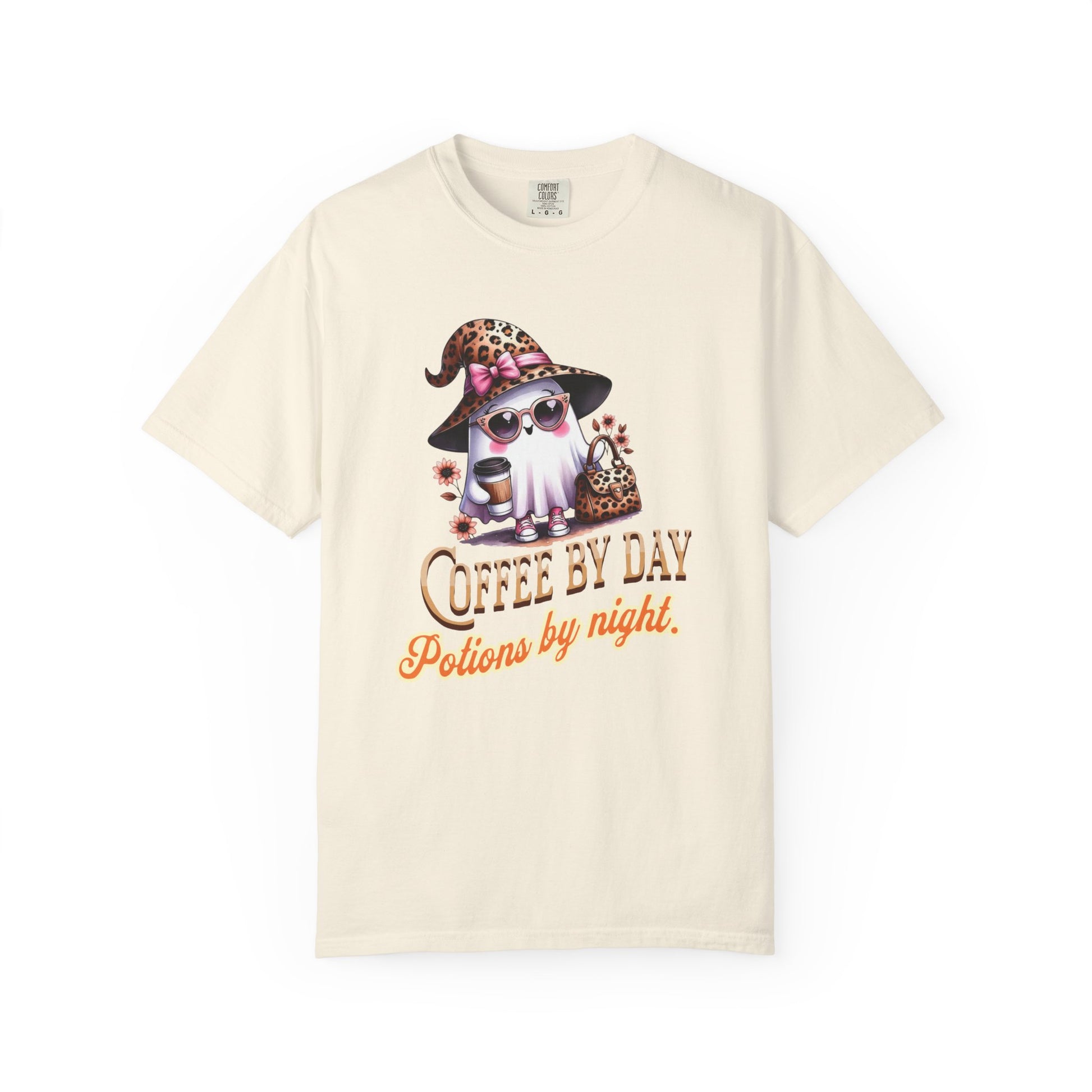 Beige t-shirt with a graphic of a cat in a witch hat and sunglasses, text 'Coffee by Day, Potions by Night' on a white background.