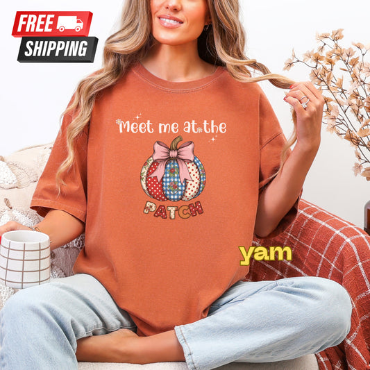 Person wearing a brown t-shirt with a pumpkin graphic and text, sitting on a couch.