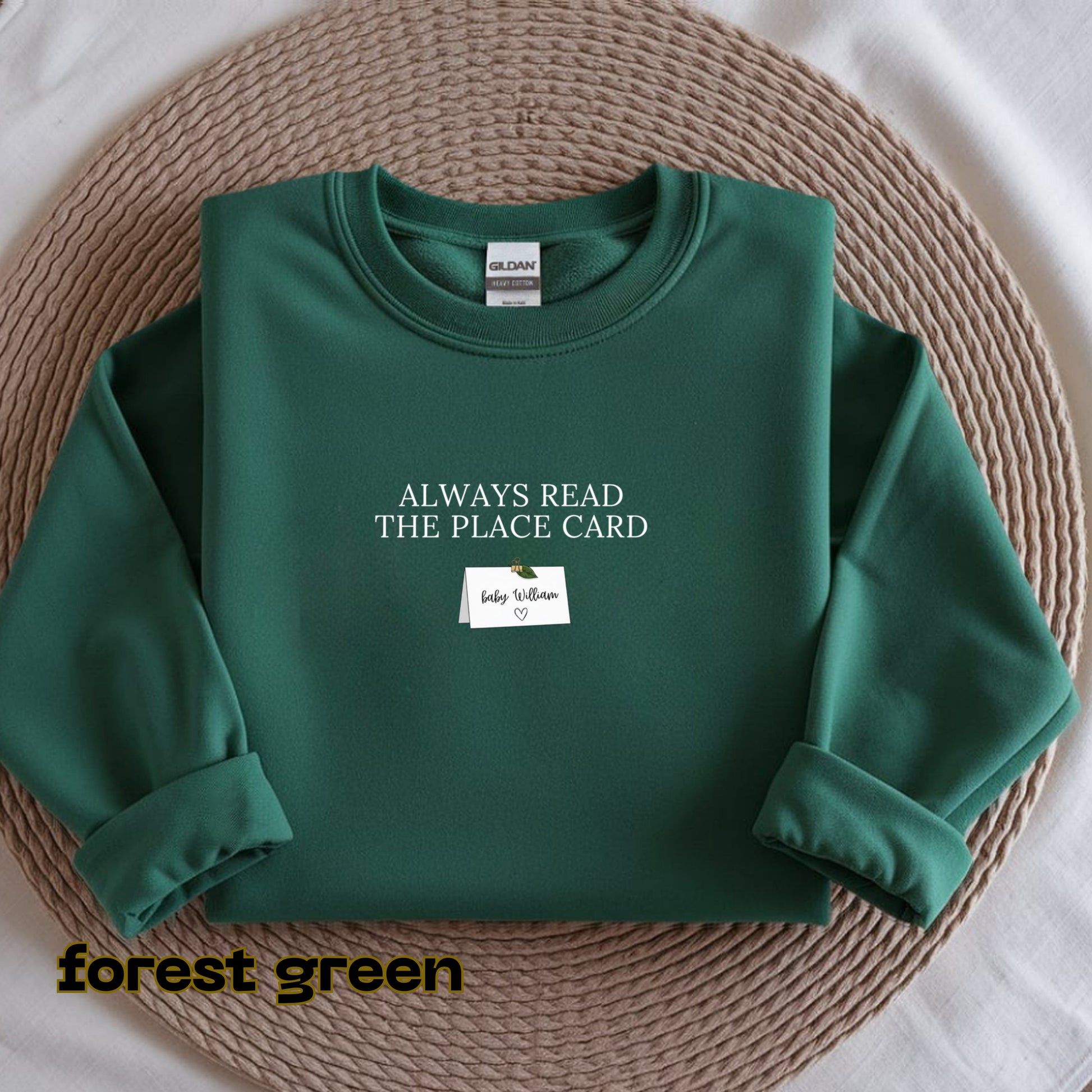 Green sweatshirt with text on a woven mat