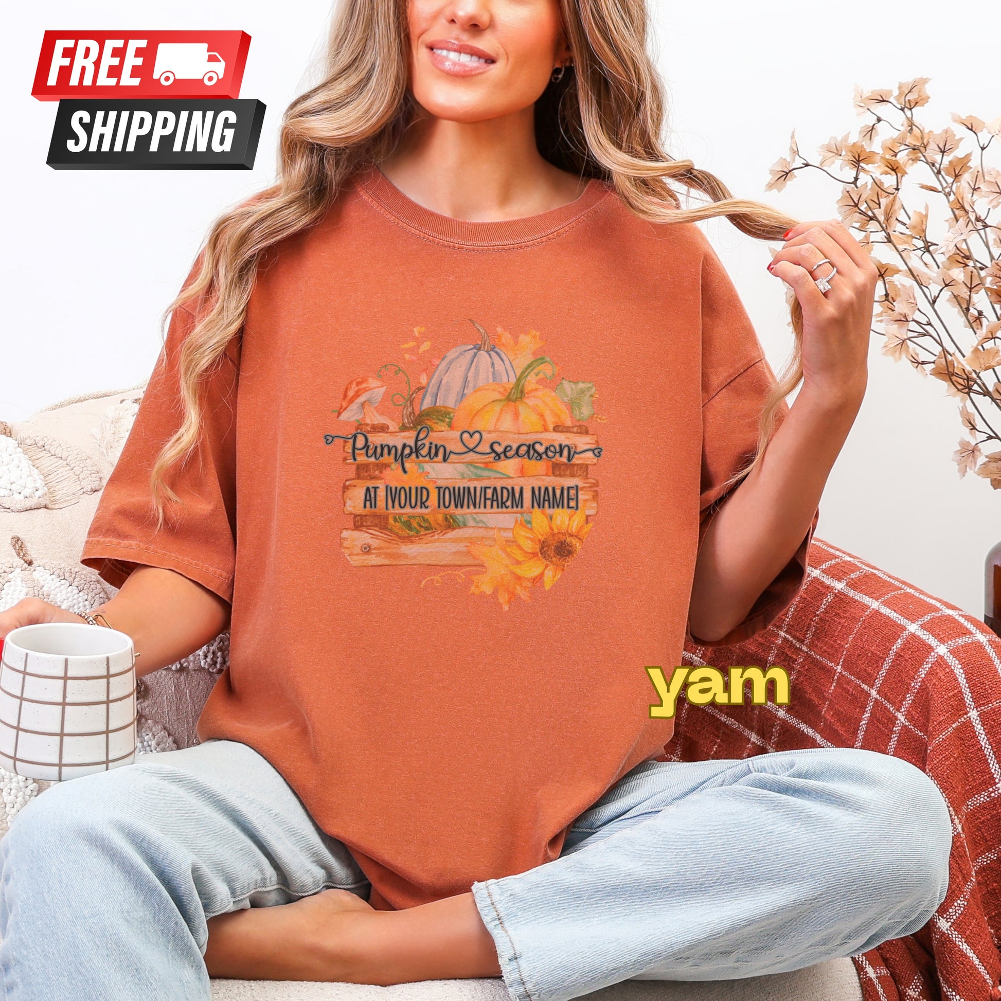 Person wearing a 'Pumpkin Season' t-shirt with a cup and plaid blanket in the background