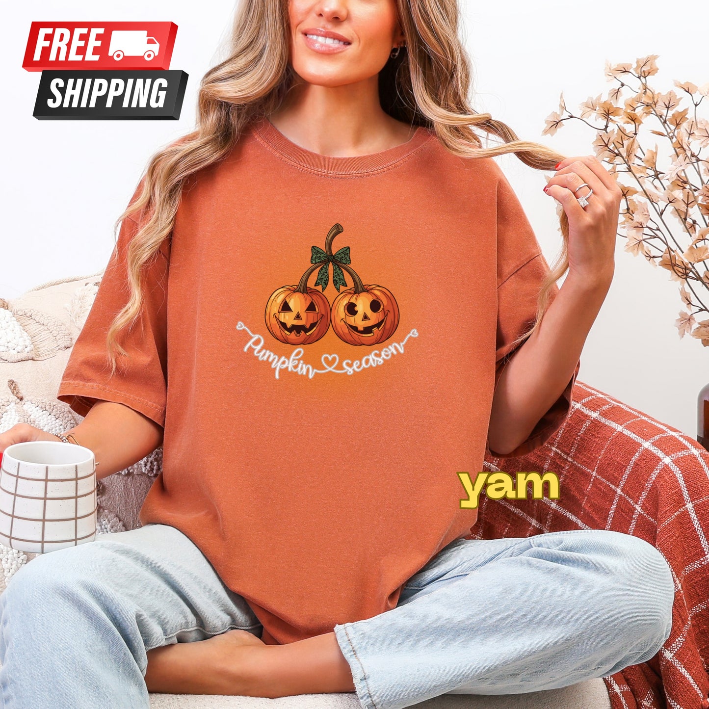 Person wearing a brown t-shirt with pumpkin design and 'Pumpkin Season' text, sitting on a couch.