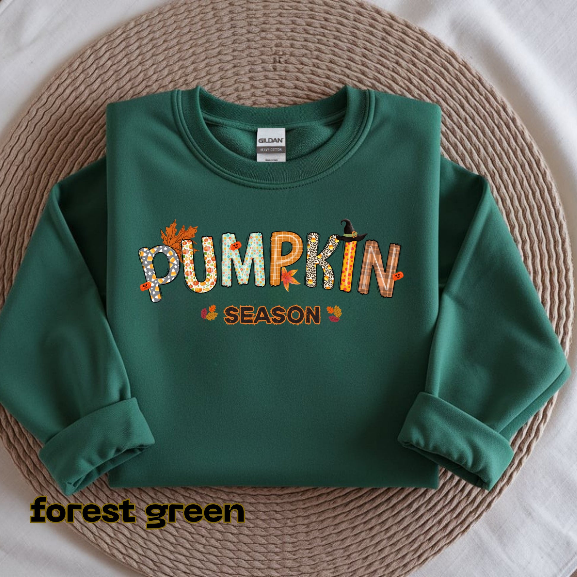 Green sweatshirt with 'Pumpkin Season' text on a textured surface
