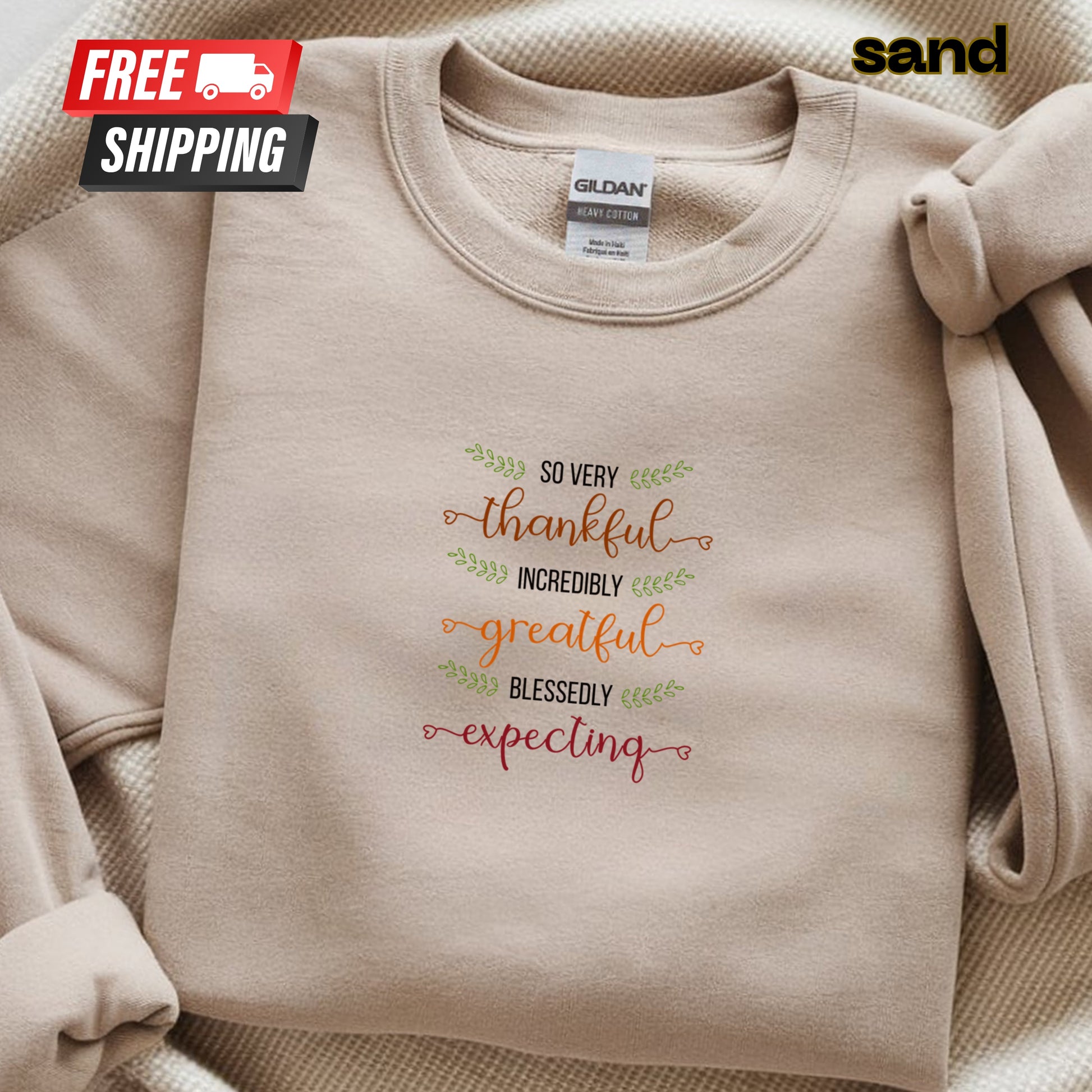 Beige sweatshirt with text design and 'sand' brand label on a beige background
