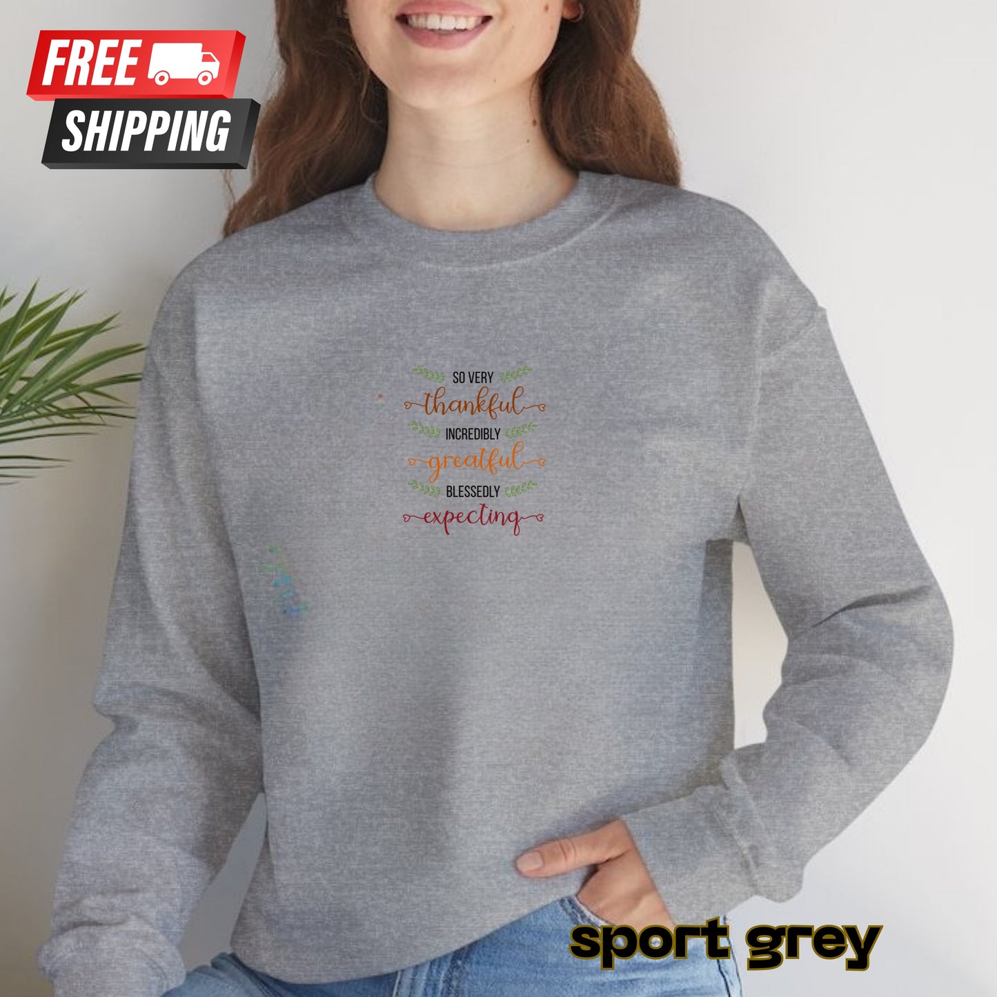 Person wearing a gray sweatshirt with colorful text design, standing against a plain background.