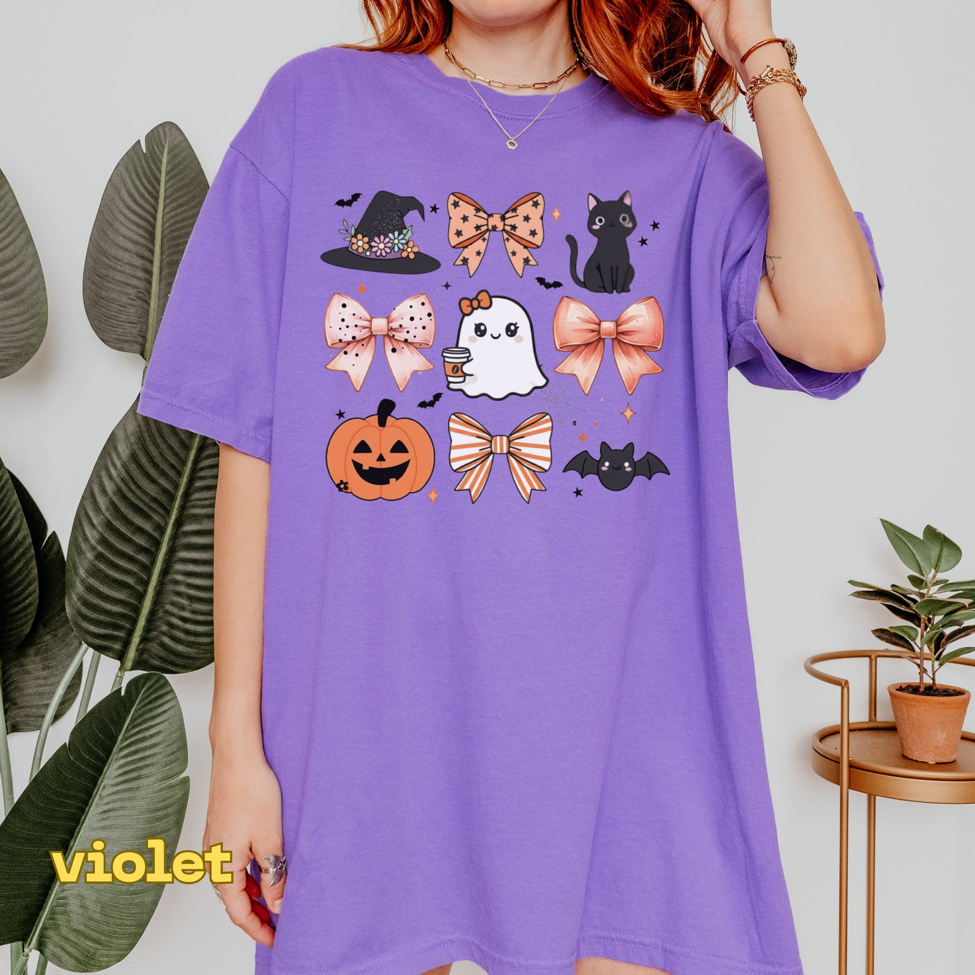Person wearing a purple t-shirt with Halloween-themed graphics against a white background.