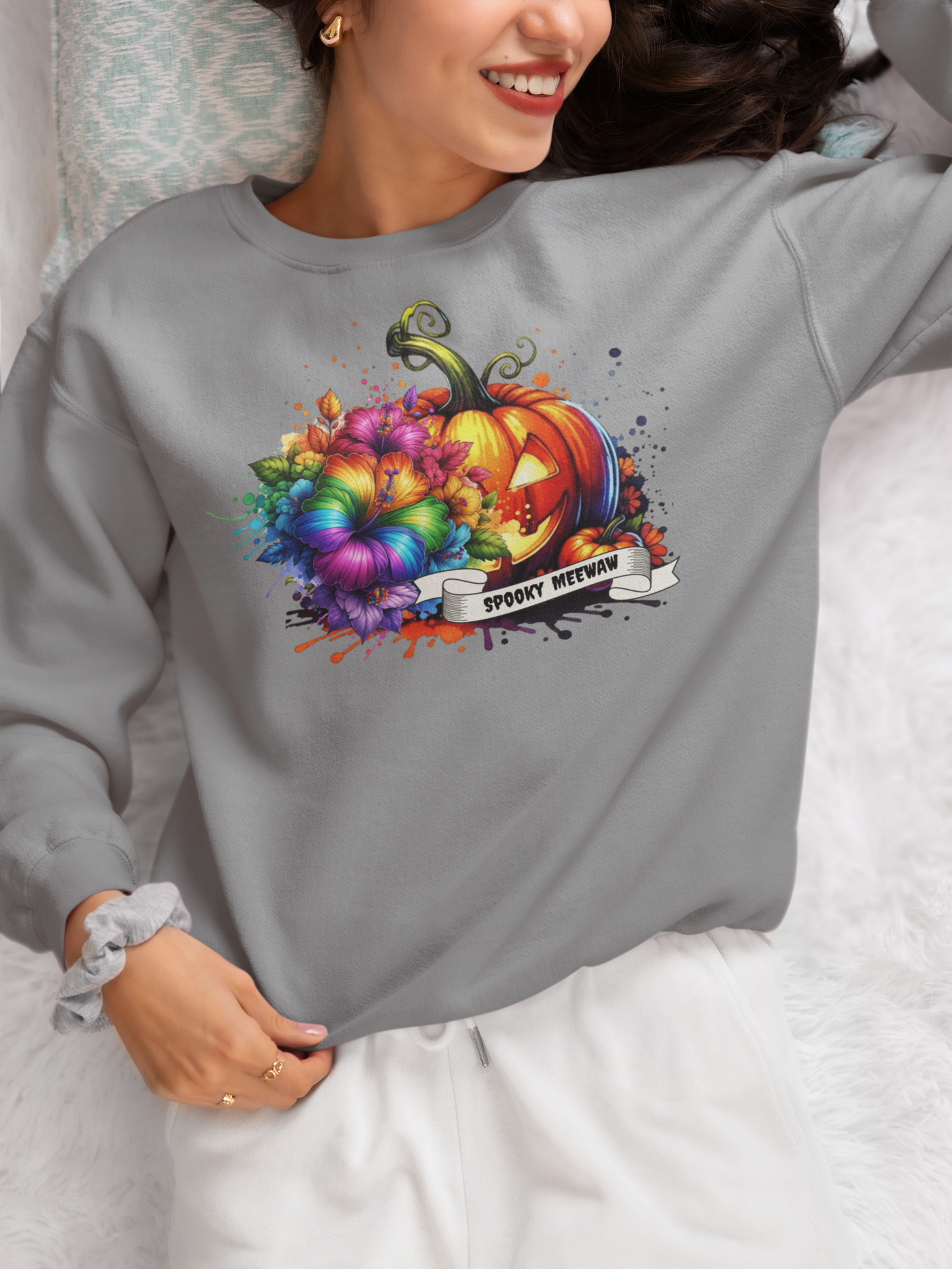 Person wearing a gray sweatshirt with a colorful Halloween design.
