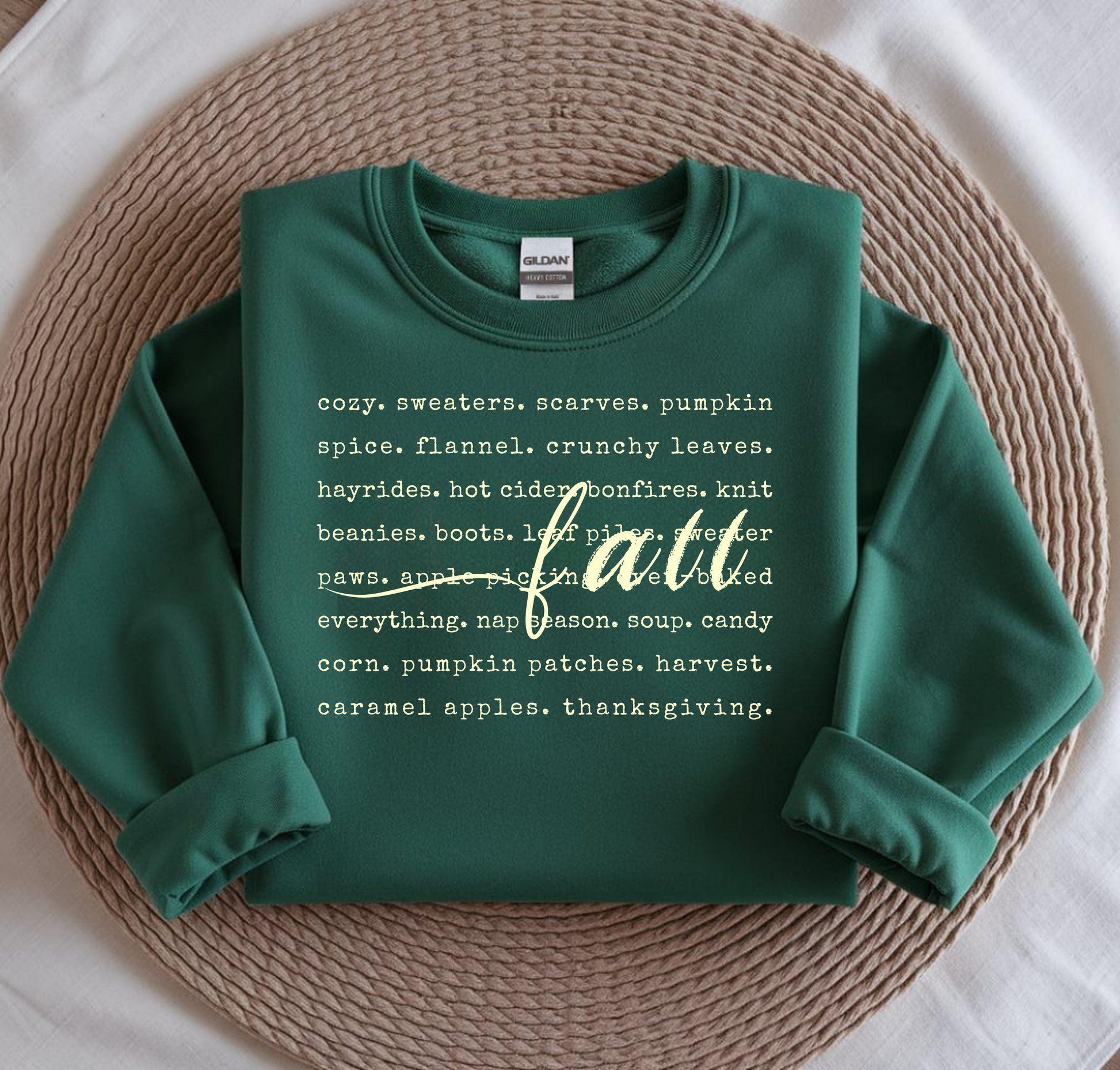 Green sweatshirt with text on a woven mat