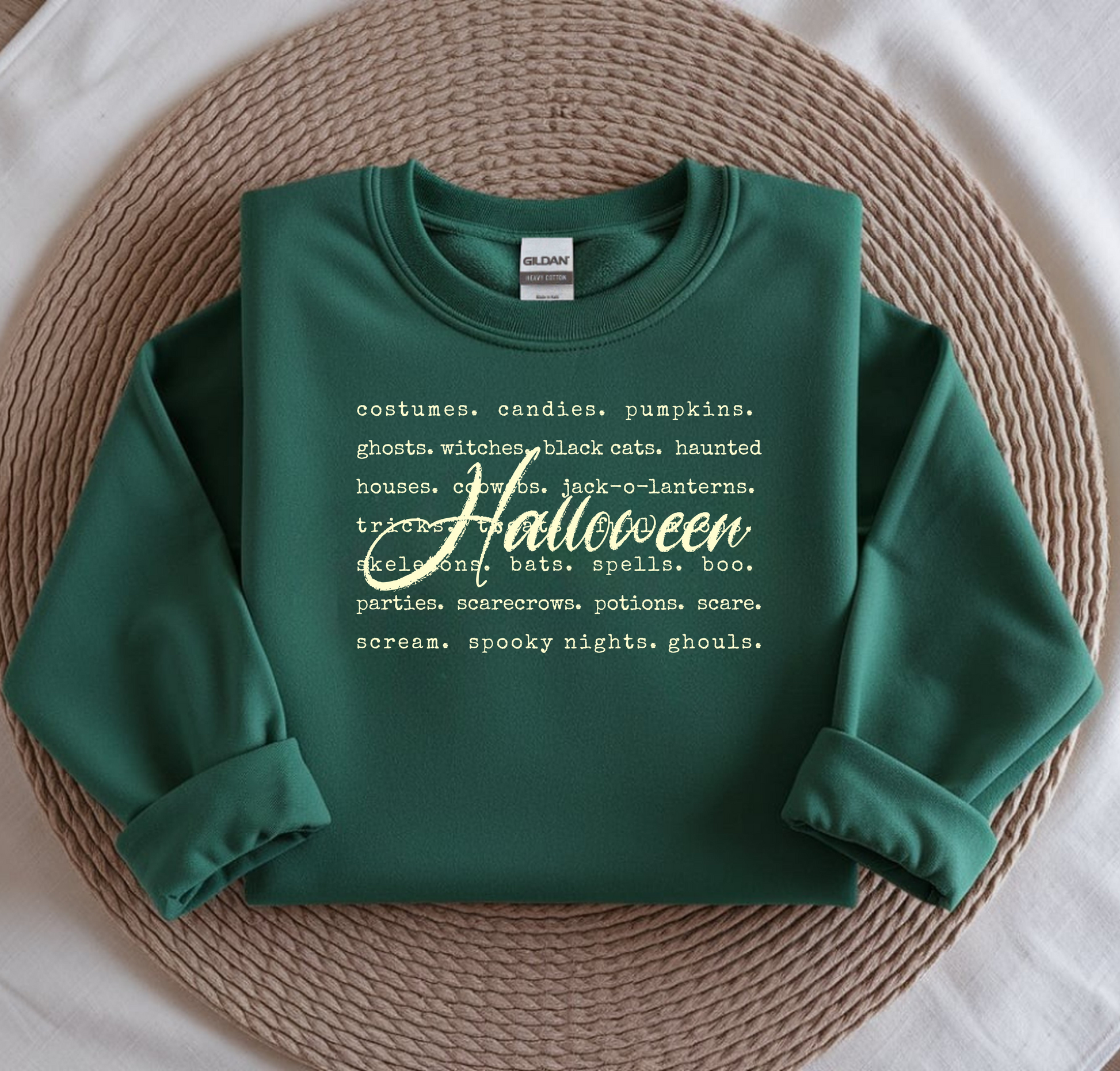 Green sweatshirt with Halloween-themed text on a woven mat