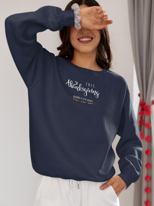 Person wearing a navy blue sweatshirt with 'This Thanksgiving' text, standing against a neutral background.