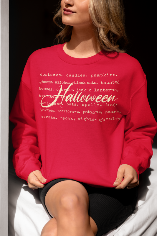 Person wearing a red sweatshirt with Halloween-themed text sitting on a white surface.