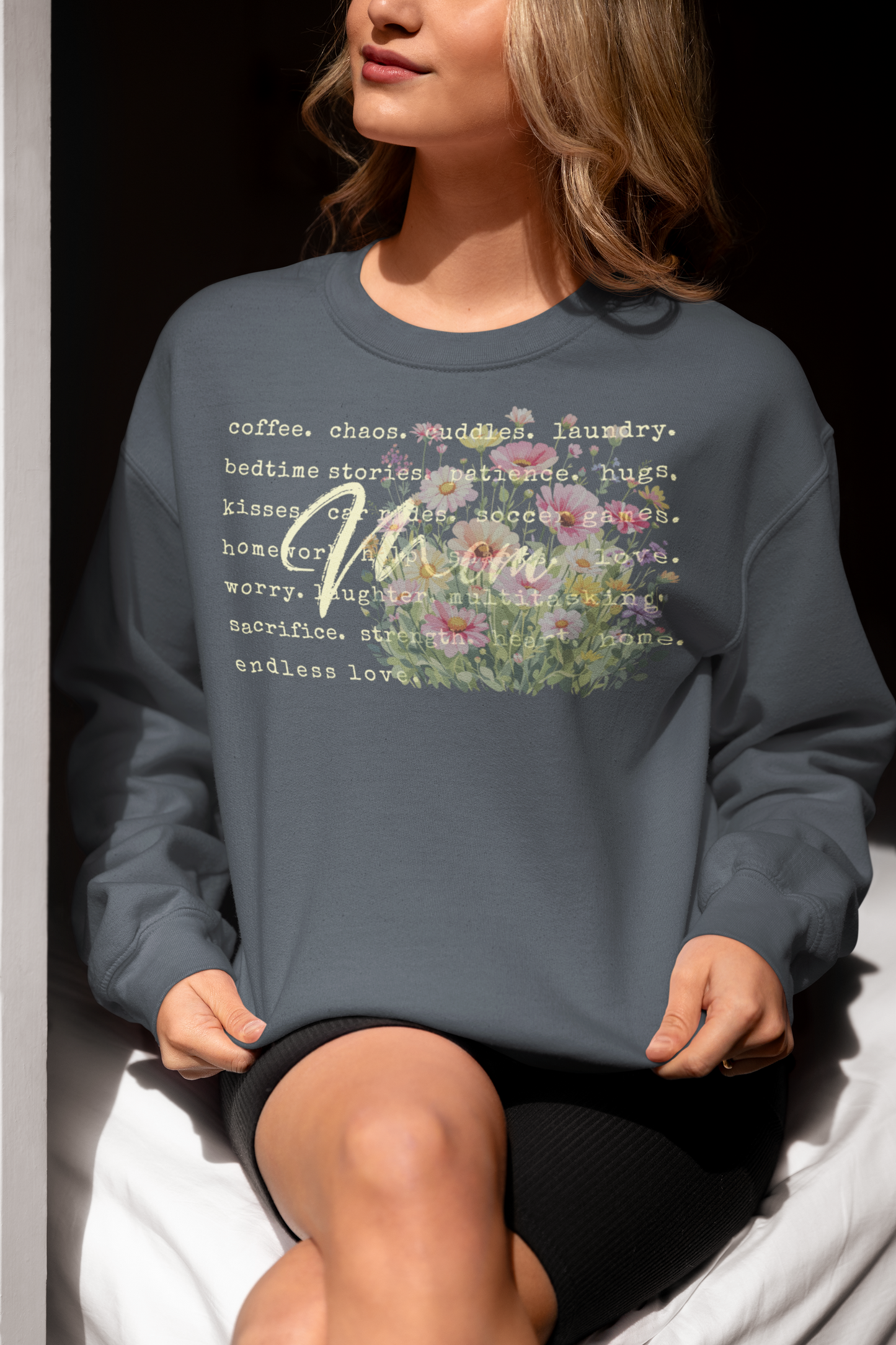 Person wearing a gray sweatshirt with text and floral design