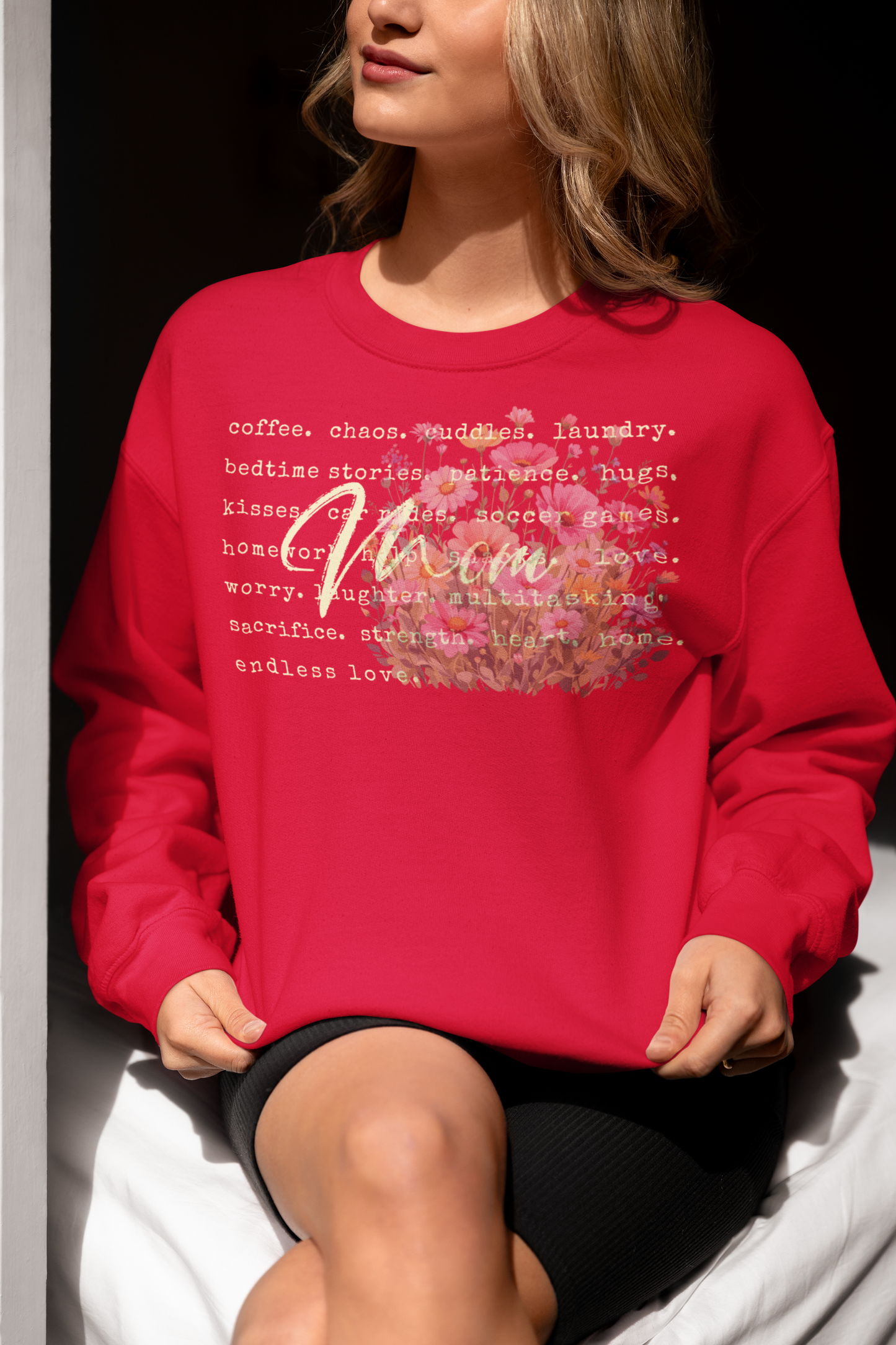 Person wearing a red sweatshirt with text and floral design