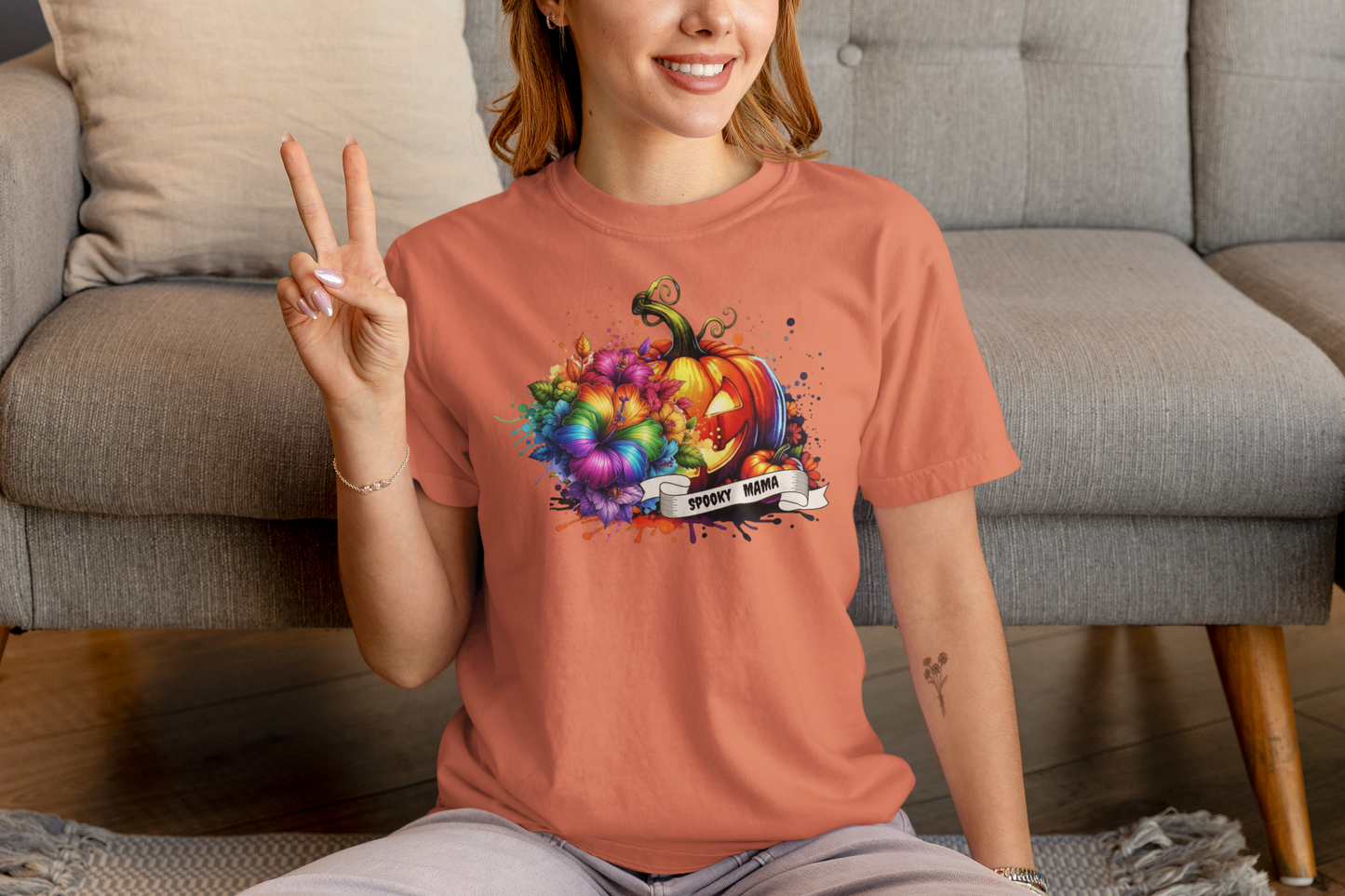 Person wearing a colorful pumpkin graphic t-shirt in a living room setting